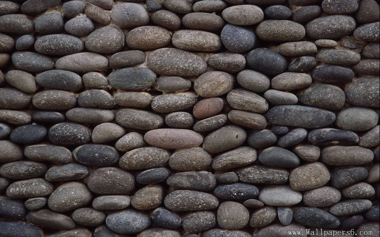 Stone 桌布 壁紙 — 特寫鏡頭：由緊密貼合的平滑河石組成的紋理牆壁，呈現不同深淺的灰色和棕色。