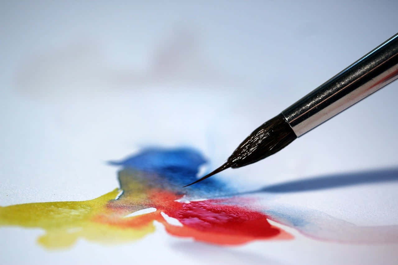 coloring 桌布 壁紙 — 特寫鏡頭：畫筆在白色紙上混合鮮豔的紅色、黃色和藍色水彩。