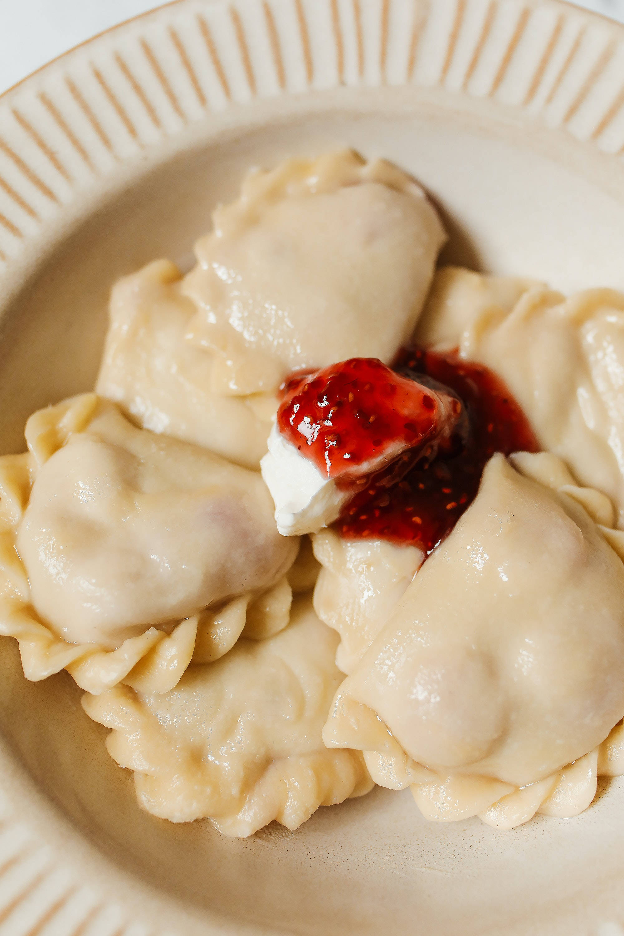 Food Photography 桌布 壁紙 — 特寫鏡頭：米色碗中的蒸餃，上面放有草莓醬和酸奶油。
