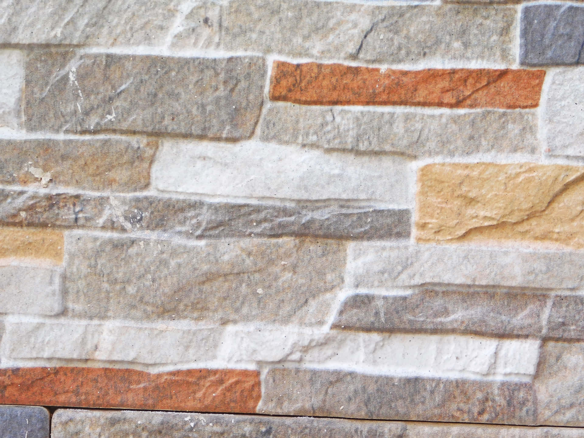 Stone texture 壁紙 — 特寫鏡頭：紋理石牆，由灰色、米色和鏽色矩形石塊交錯排列成水平行。