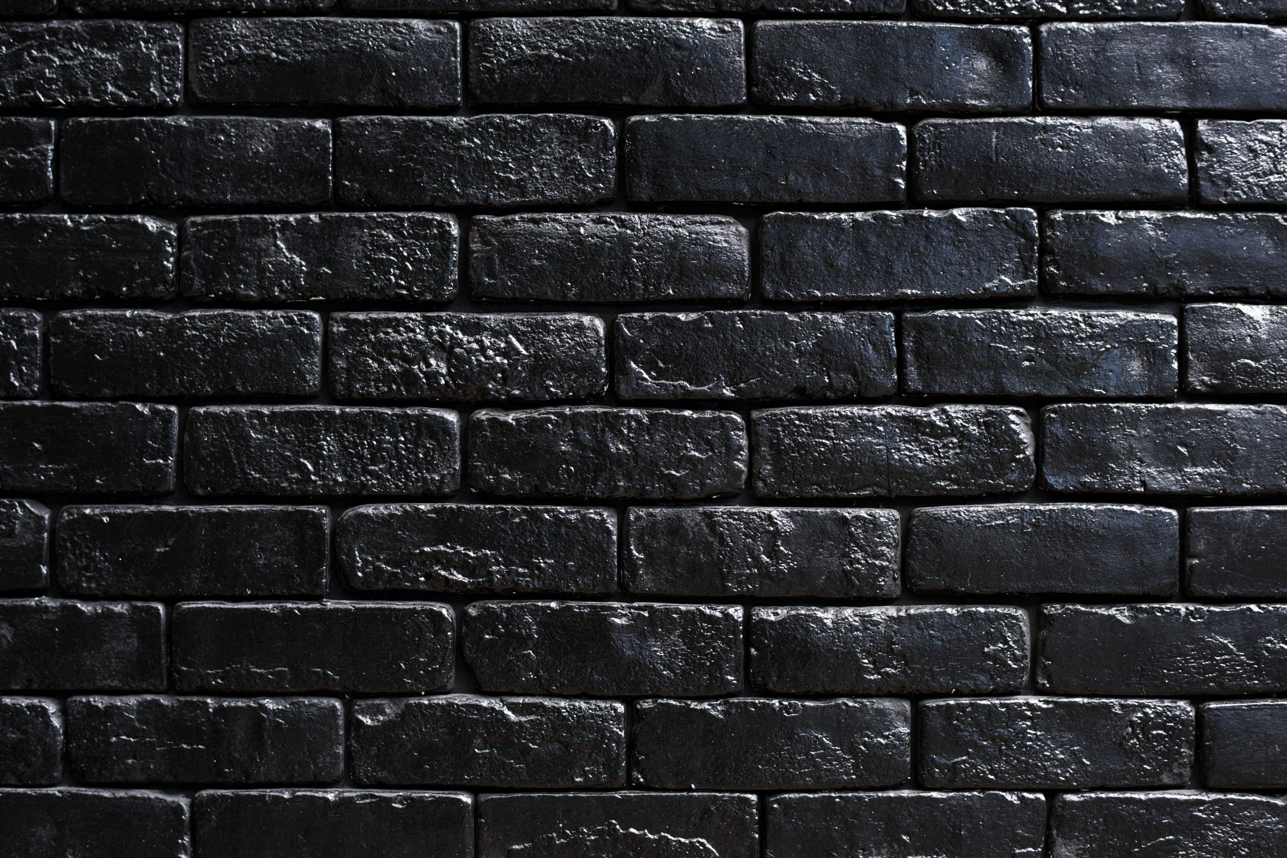 Stone Wall 桌布 壁紙 — 特寫鏡頭：紋理黑色磚牆，帶有細微灰色亮點和粗糙砂漿線。