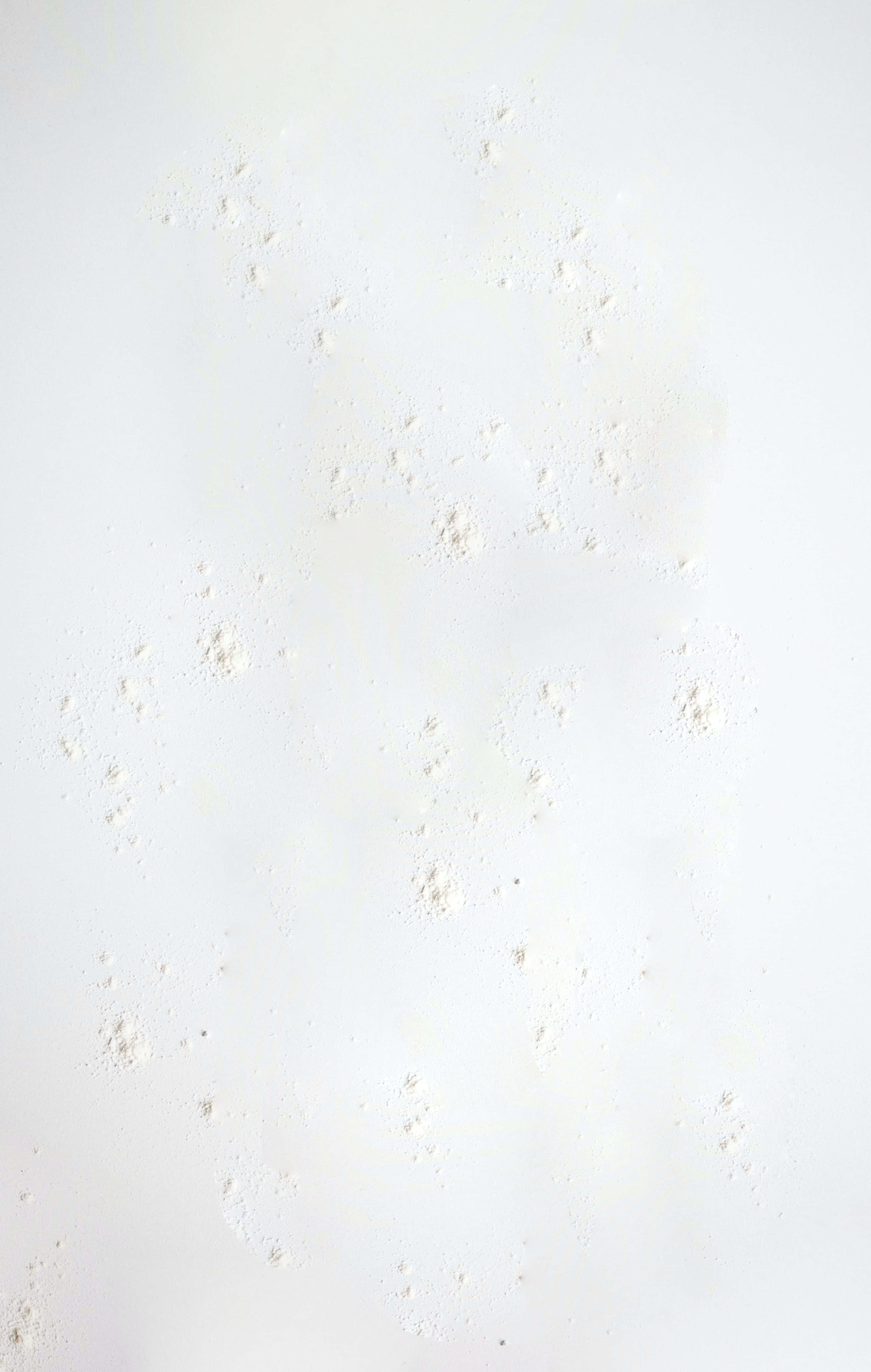 Rough Texture 桌布 壁紙 — 特寫鏡頭，細膩的白色粉末顆粒散落在柔軟的米白色表面上，帶有微妙的漸變照明。