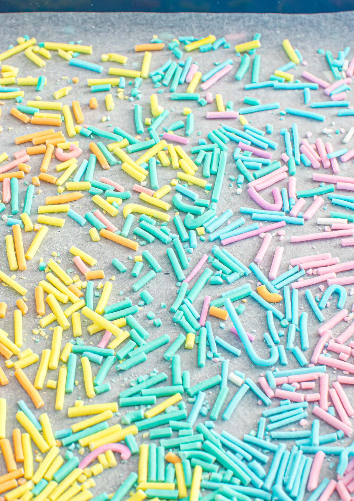 Sprinkle 桌布 壁紙 — 特寫鏡頭，色彩繽紛的粉彩色糖果碎散落在烤盤上。