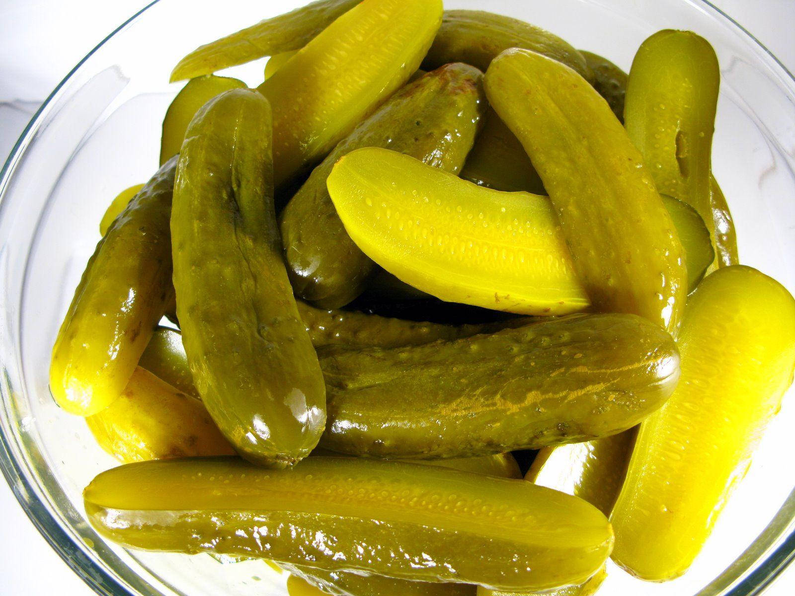 Pickle 桌布 壁紙 — 特寫鏡頭：透明玻璃碗中堆疊著光澤的黃綠色蒔蘿泡菜，背景為白色。