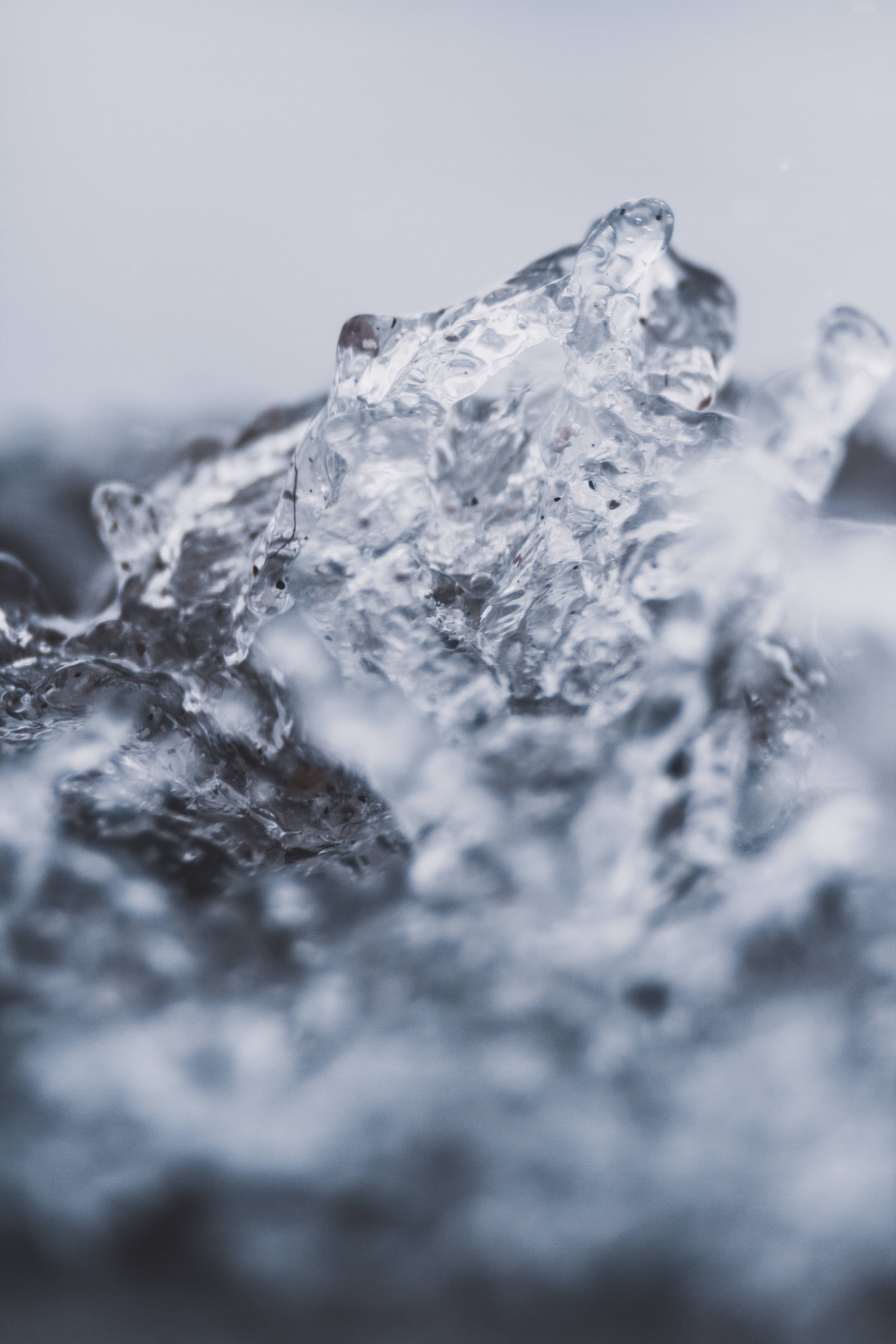 水 桌布 壁紙 — 特寫鏡頭：鋸齒狀半透明冰片在柔和的模糊背景下閃爍著水氣。