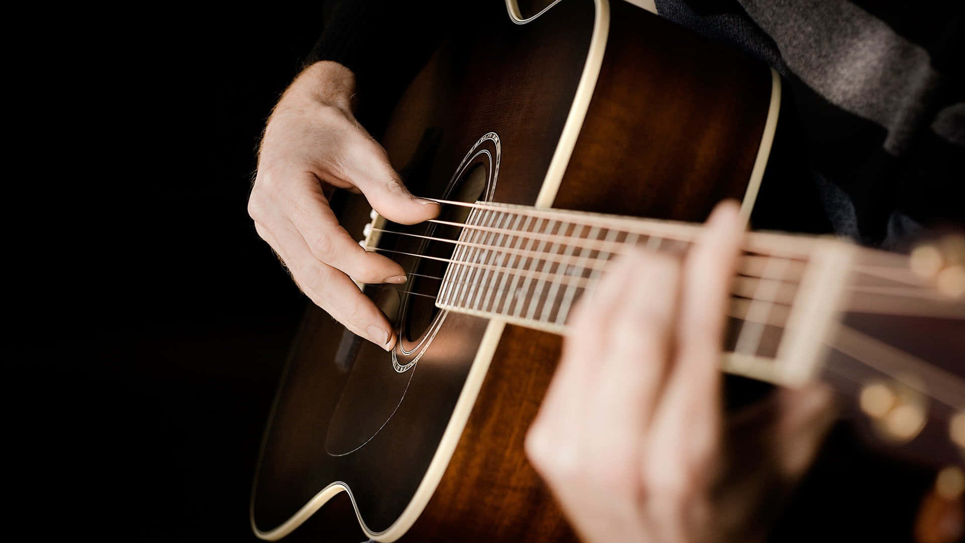Guitar Aesthetic 桌布 壁紙 — 特寫鏡頭，雙手熟練地在深色背景上彈奏原聲吉他。