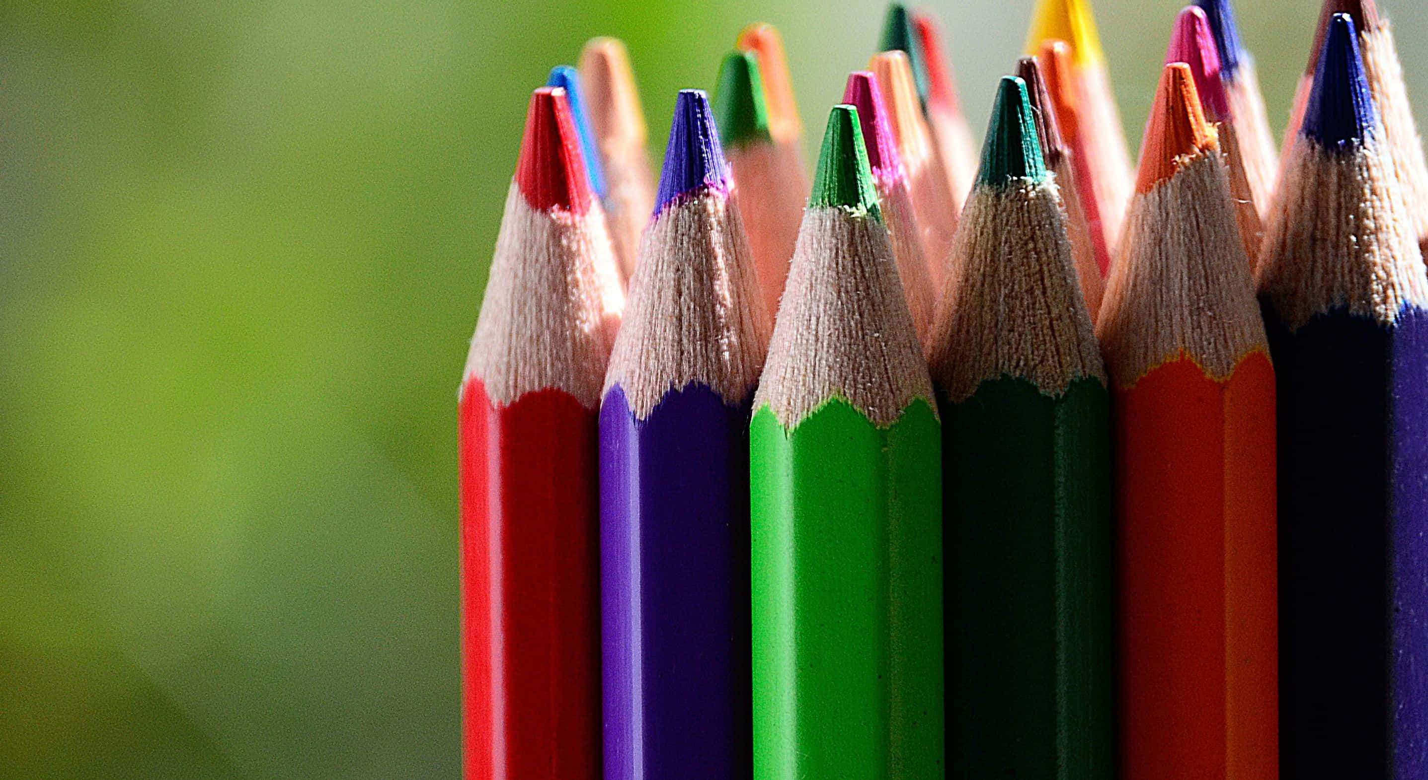 pencil 桌布 壁紙 — 特寫鏡頭，顯示削尖的彩色鉛筆直立，背景為柔和的綠色模糊效果。