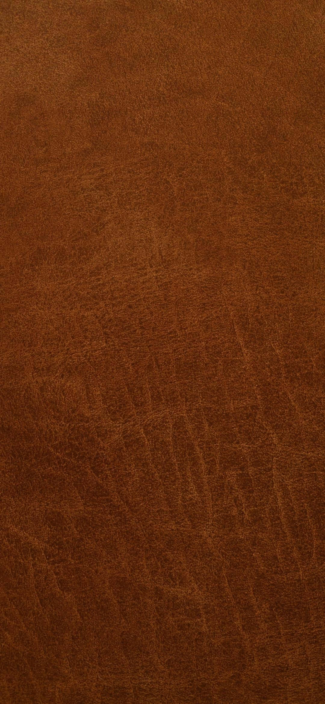Dark Brown 桌布 壁紙 — 特寫鏡頭下的濃郁棕色皮革，帶有天然紋理和柔和光線下的細微摺痕。
