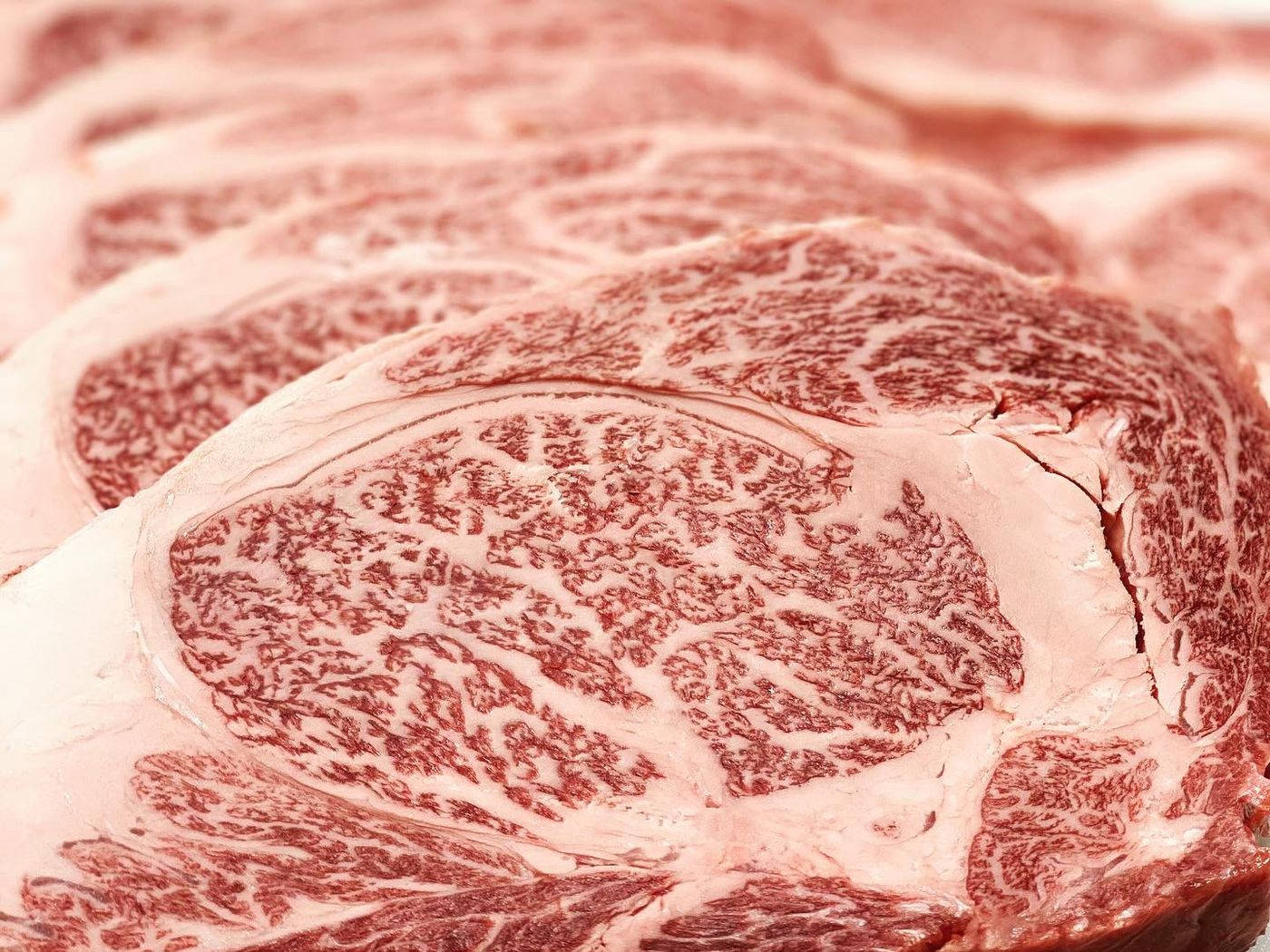 meat 桌布 壁紙 — 特寫鏡頭展示大理石紋生牛肉排，呈現複雜的脂肪紋理和豐富的紅色。