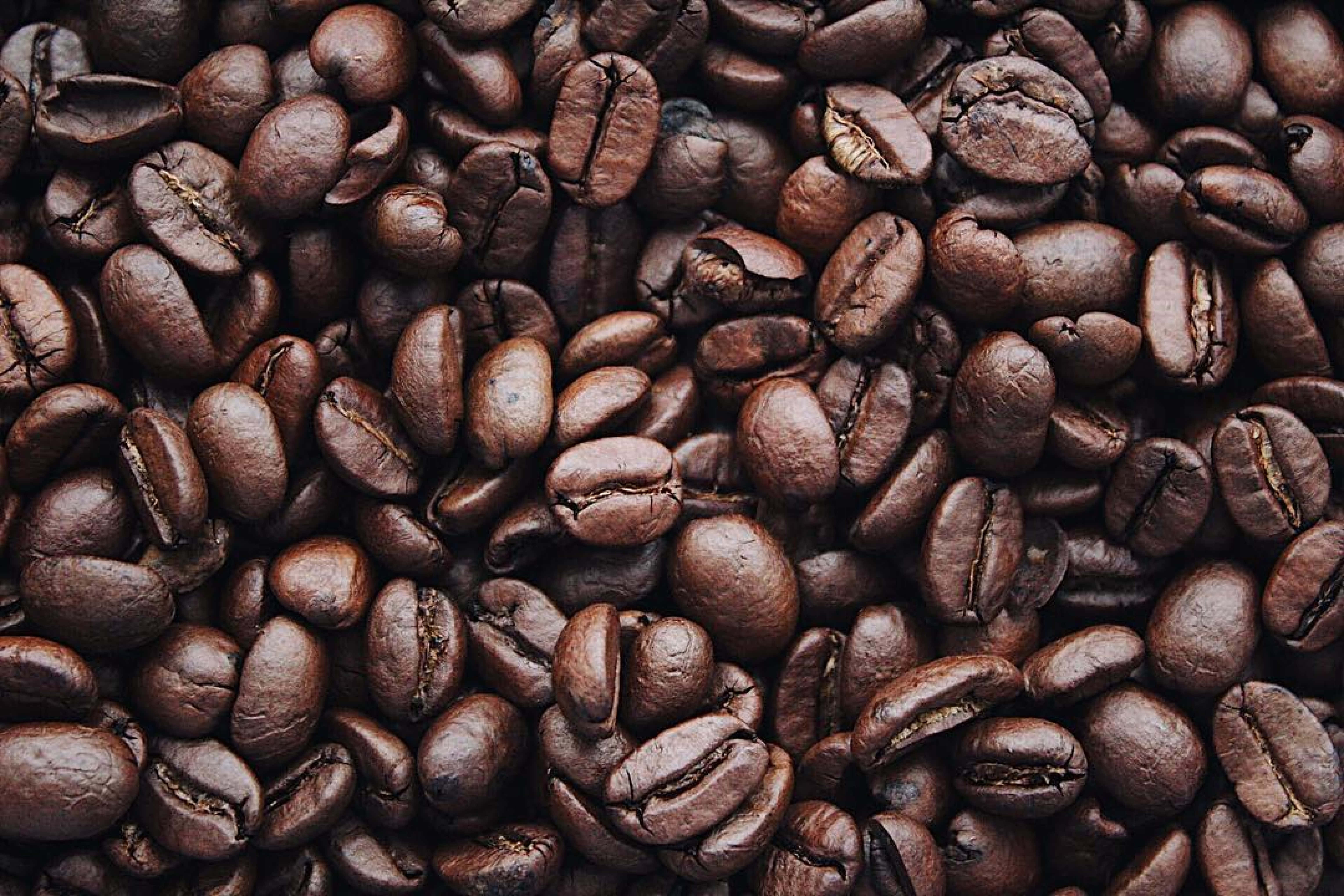 Coffee Beans 桌布 壁紙 — 特寫鏡頭展示濃郁深烘焙咖啡豆，表面帶有紋理和自然裂紋。