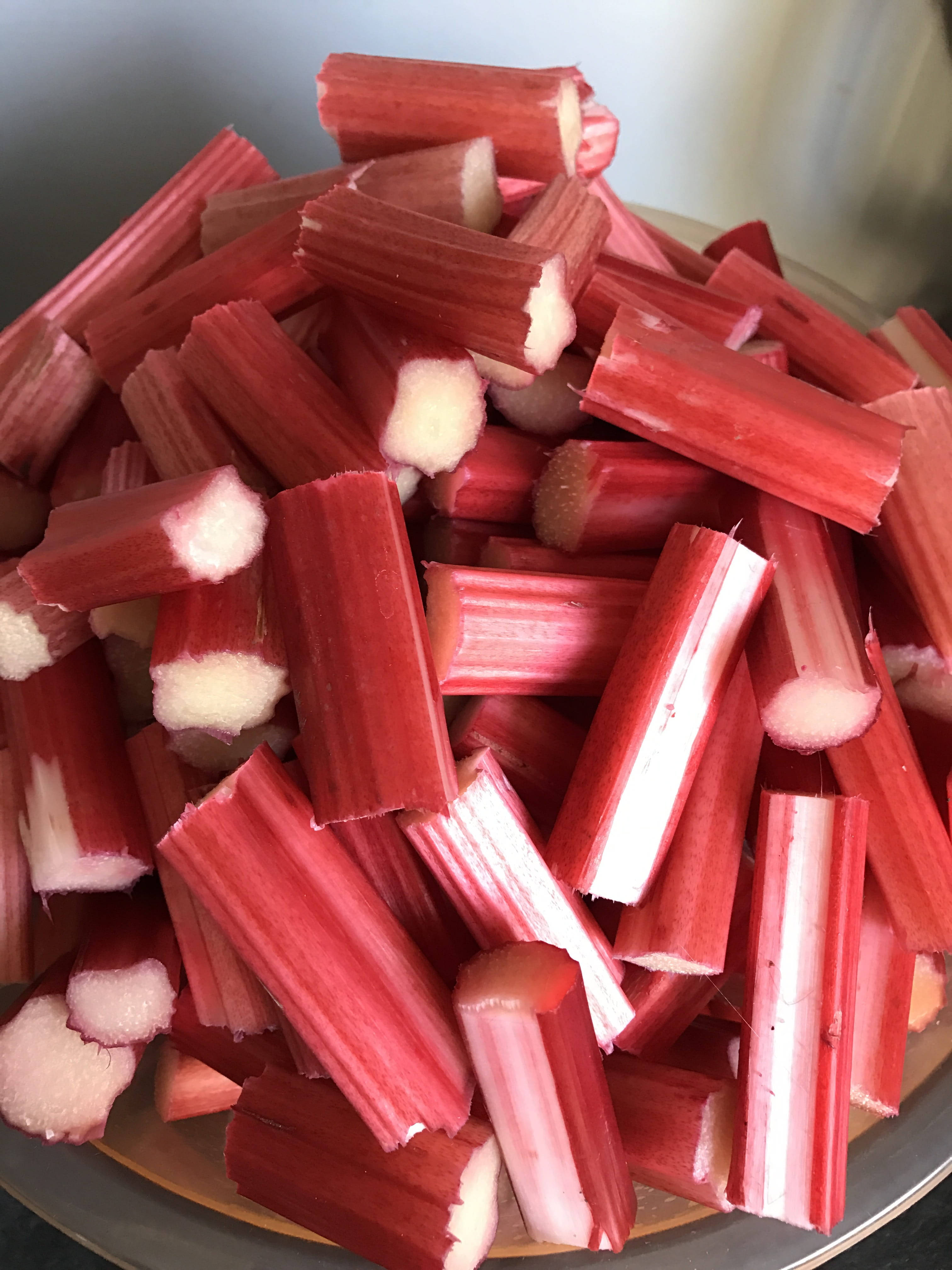Vegetable 桌布 壁紙 — 特寫鏡頭顯示新鮮切好的大黃莖高高堆在碗中，呈現鮮紅色的外皮和淡白色的內部。