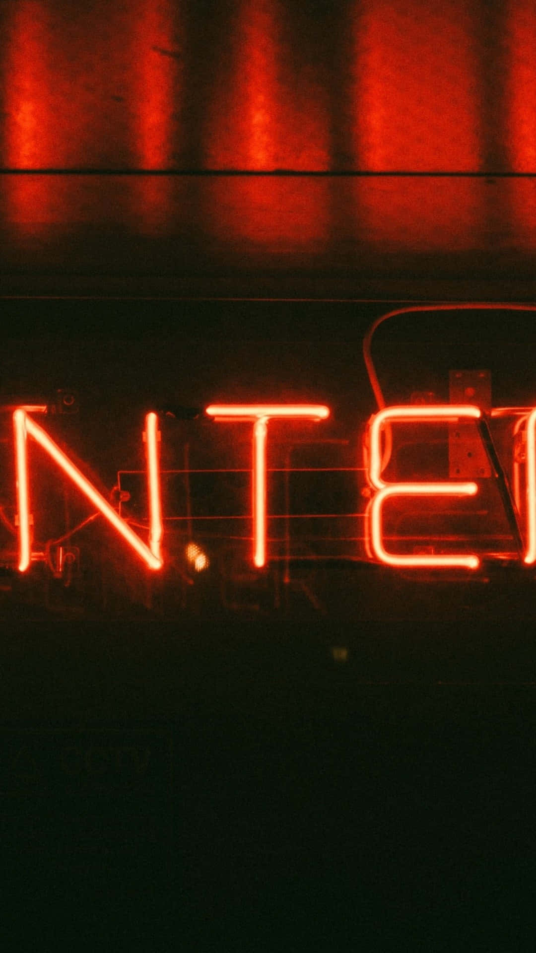 neon sign 桌布 壁紙 — 特寫鏡頭顯示發光的紅色霓虹燈字母拼出 'NTE'，背景為深色，帶有垂直光反射。