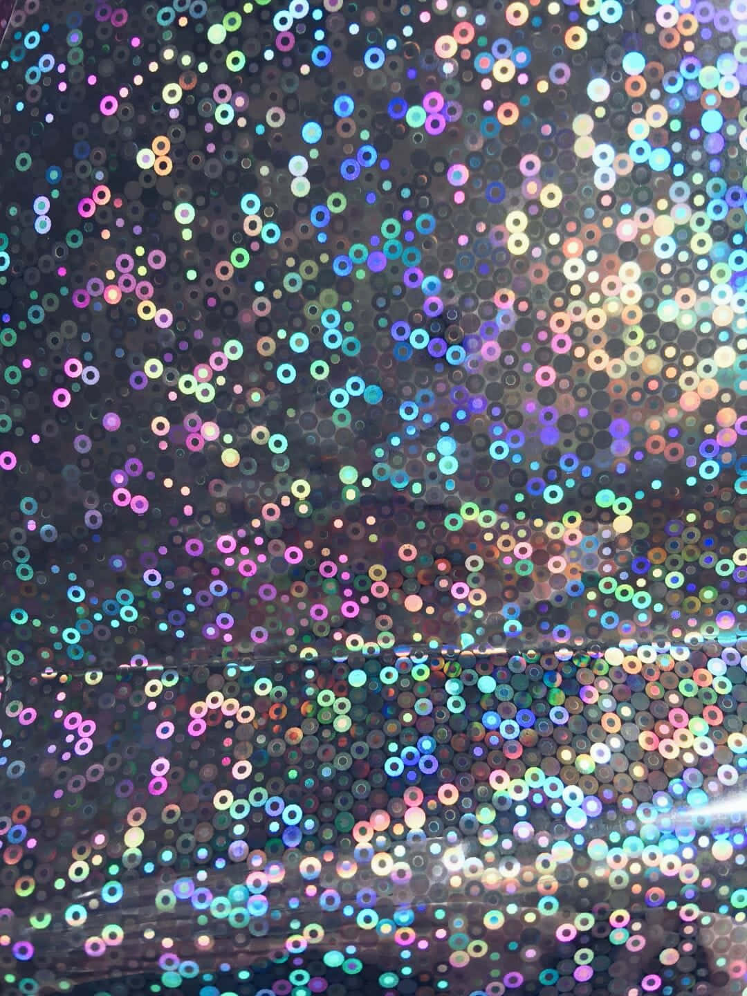 Rainbow Glitter 桌布 壁紙 — 特寫閃爍全息亮片在深色背景上反射彩虹色調。