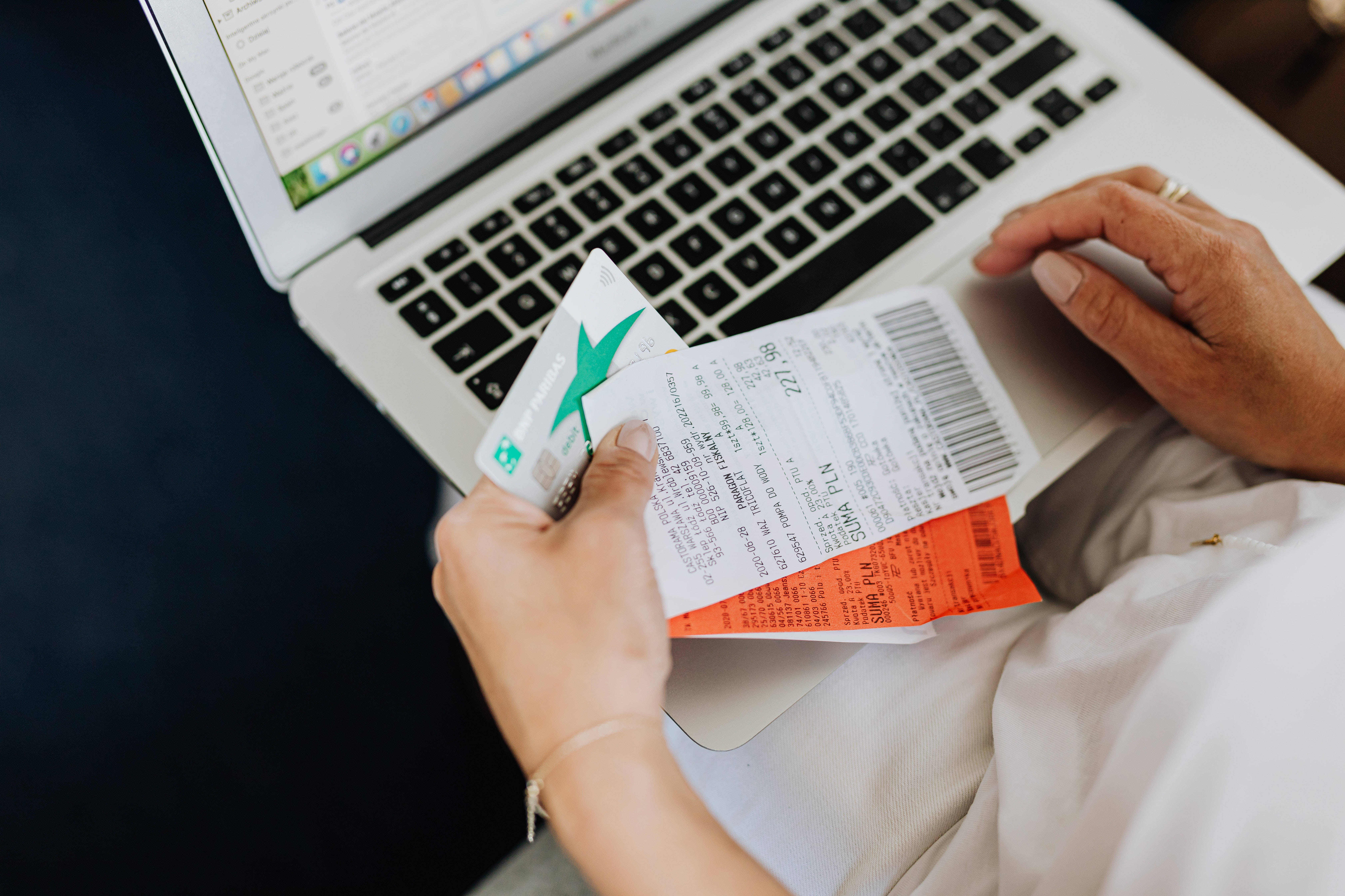 Sales 桌布 壁紙 — 特寫雙手拿著旅行機票和信用卡在打開的筆記型電腦鍵盤上方。