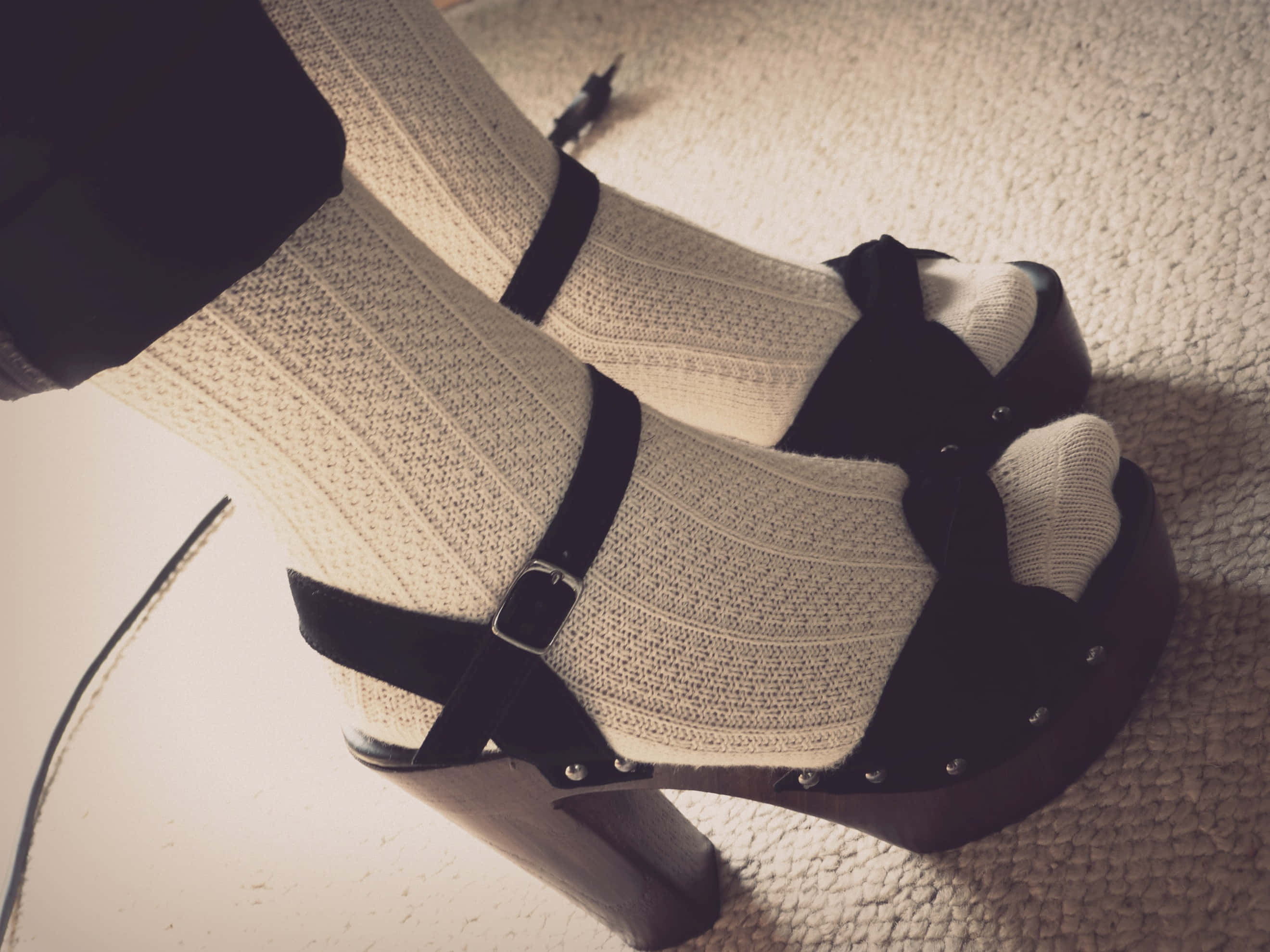 Footwear Design 桌布 壁紙 — 特寫雙腳穿著厚底黑色平台涼鞋和奶油色羅紋襪子，站在有紋理的地毯上。