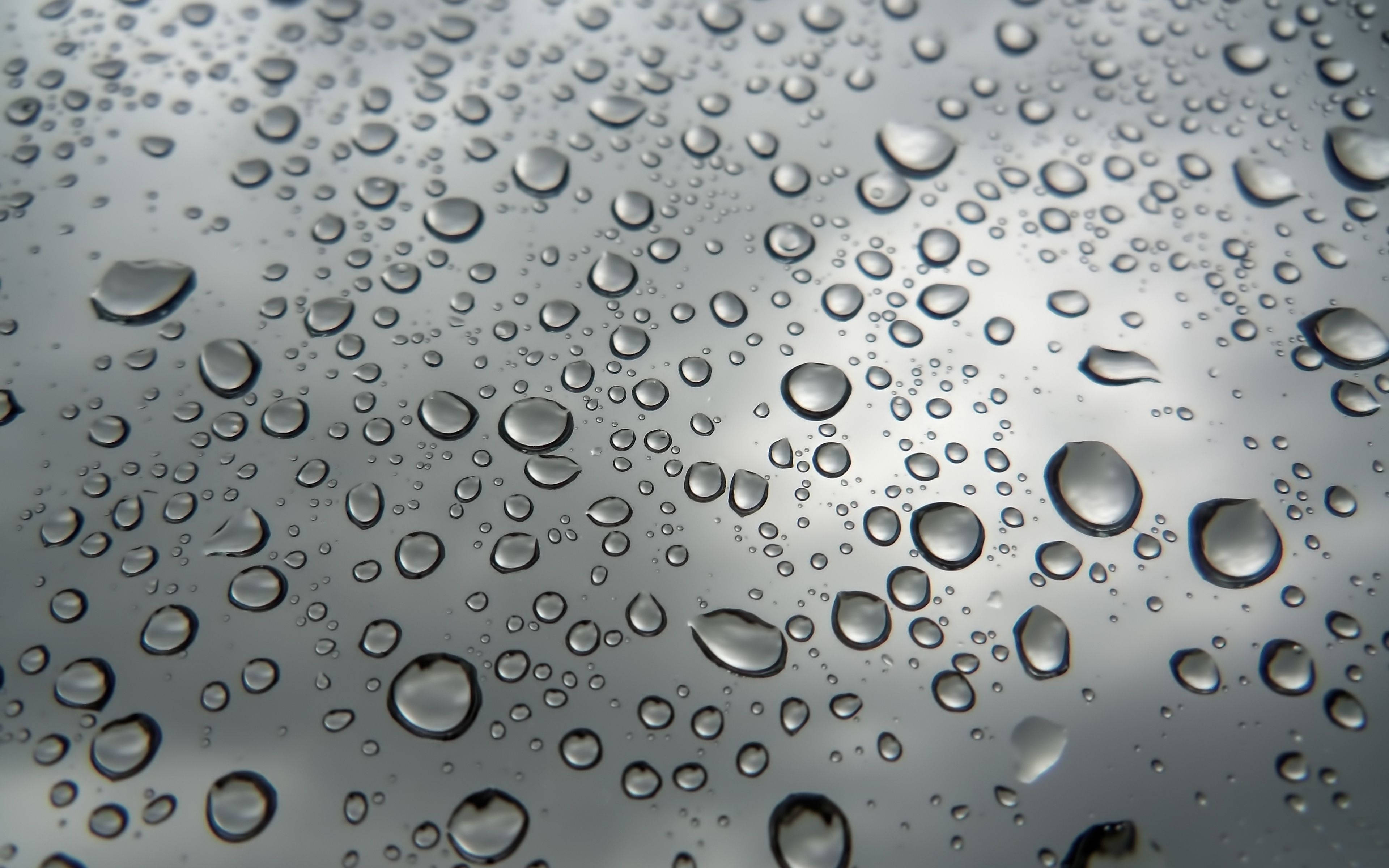 Rainy Day 桌布 壁紙 — 特寫雨滴依附在玻璃表面，背景為模糊的灰色天空。
