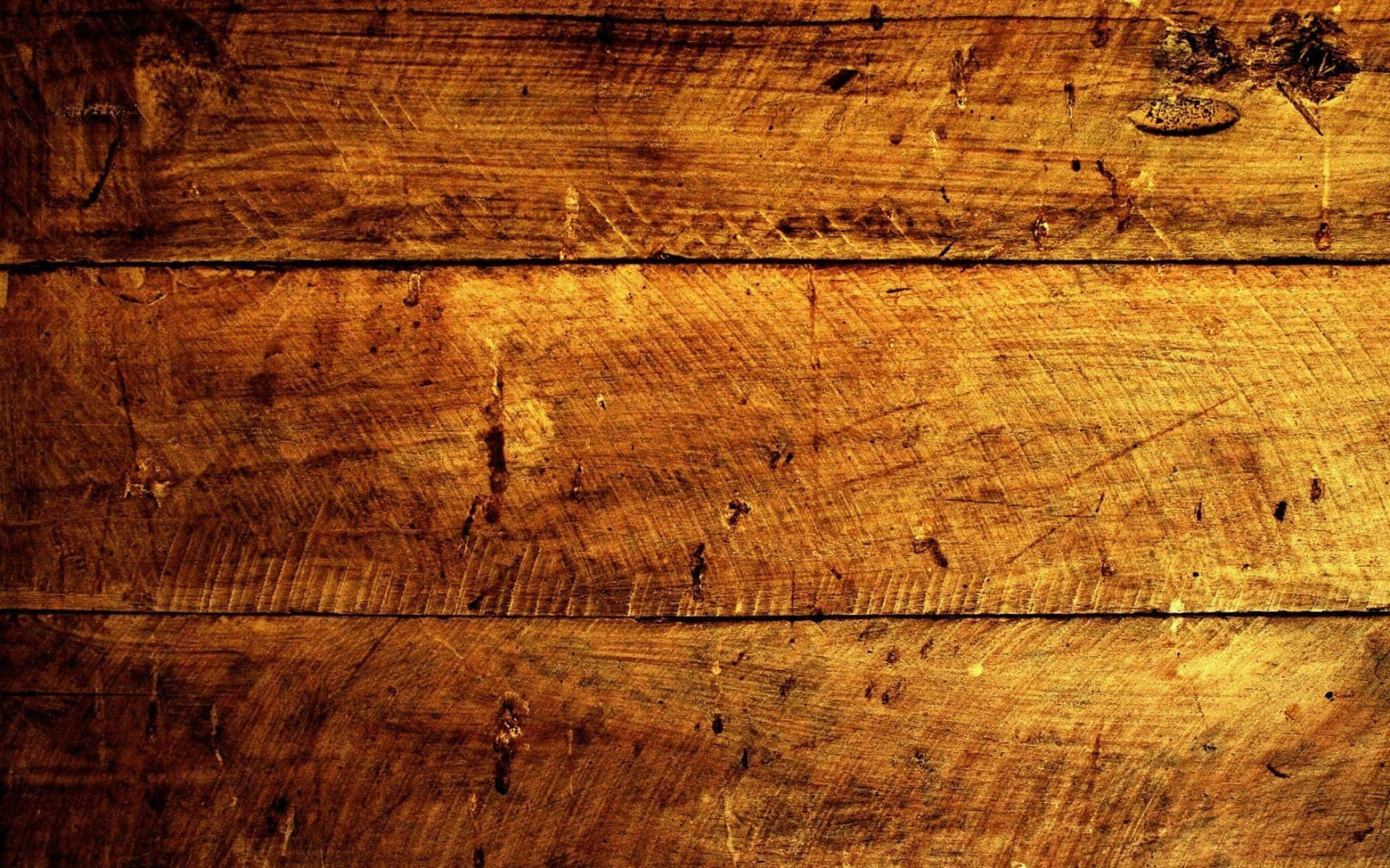 Wood Grain 桌布 壁紙 — 特寫風化木板，帶有豐富琥珀色調和可見的木紋刮痕，在溫暖燈光下。