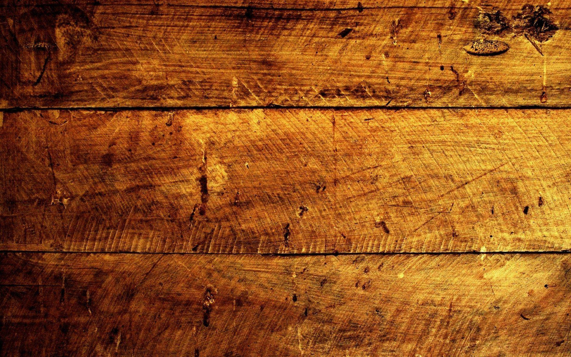 Wood Texture 桌布 壁紙 — 特寫風化木板的豐富琥珀色調，在溫暖燈光下可見木紋刮痕。