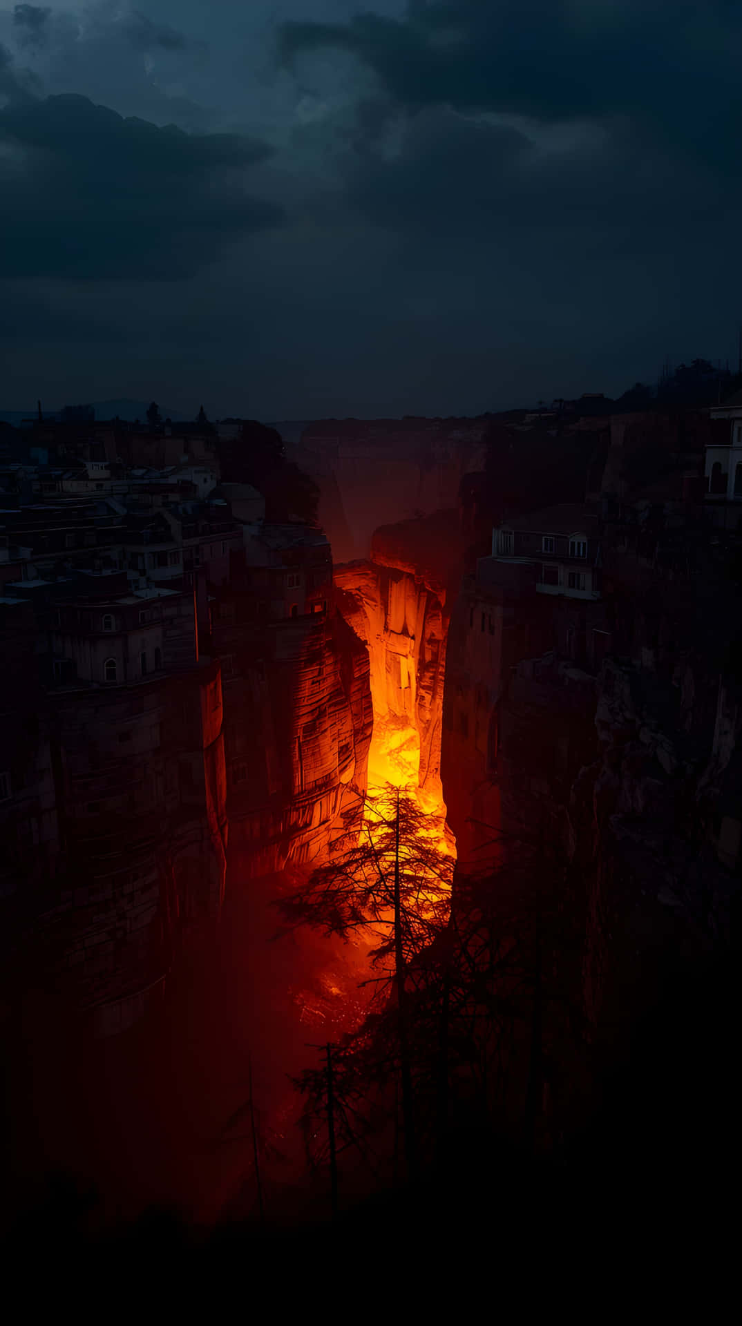 Dark Mountain Valley with Orange Light 壁紙 — 狹窄的峽谷在暴風雨的夜空下，在 towering 的黑暗岩層之間流淌著火熱的橙色熔岩，發出光芒。