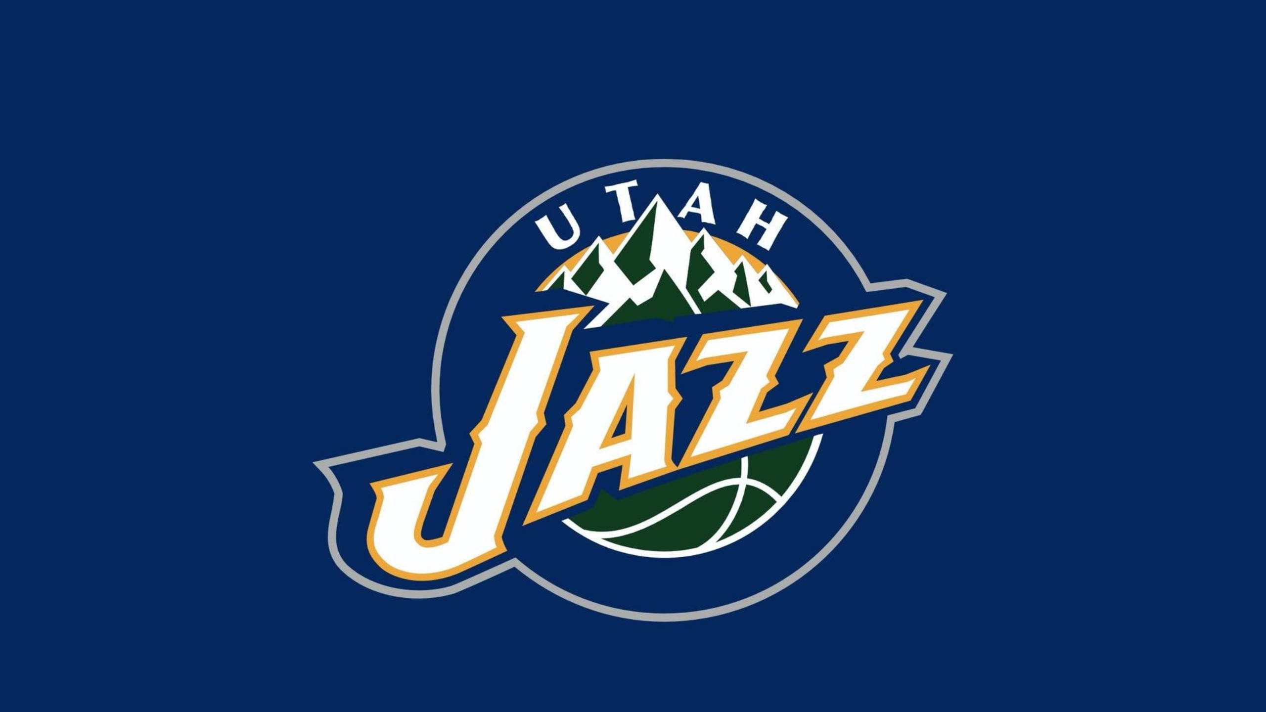 Utah 桌布 壁紙 — 猶他爵士隊標誌，帶有山峰和籃球，背景為深藍色。