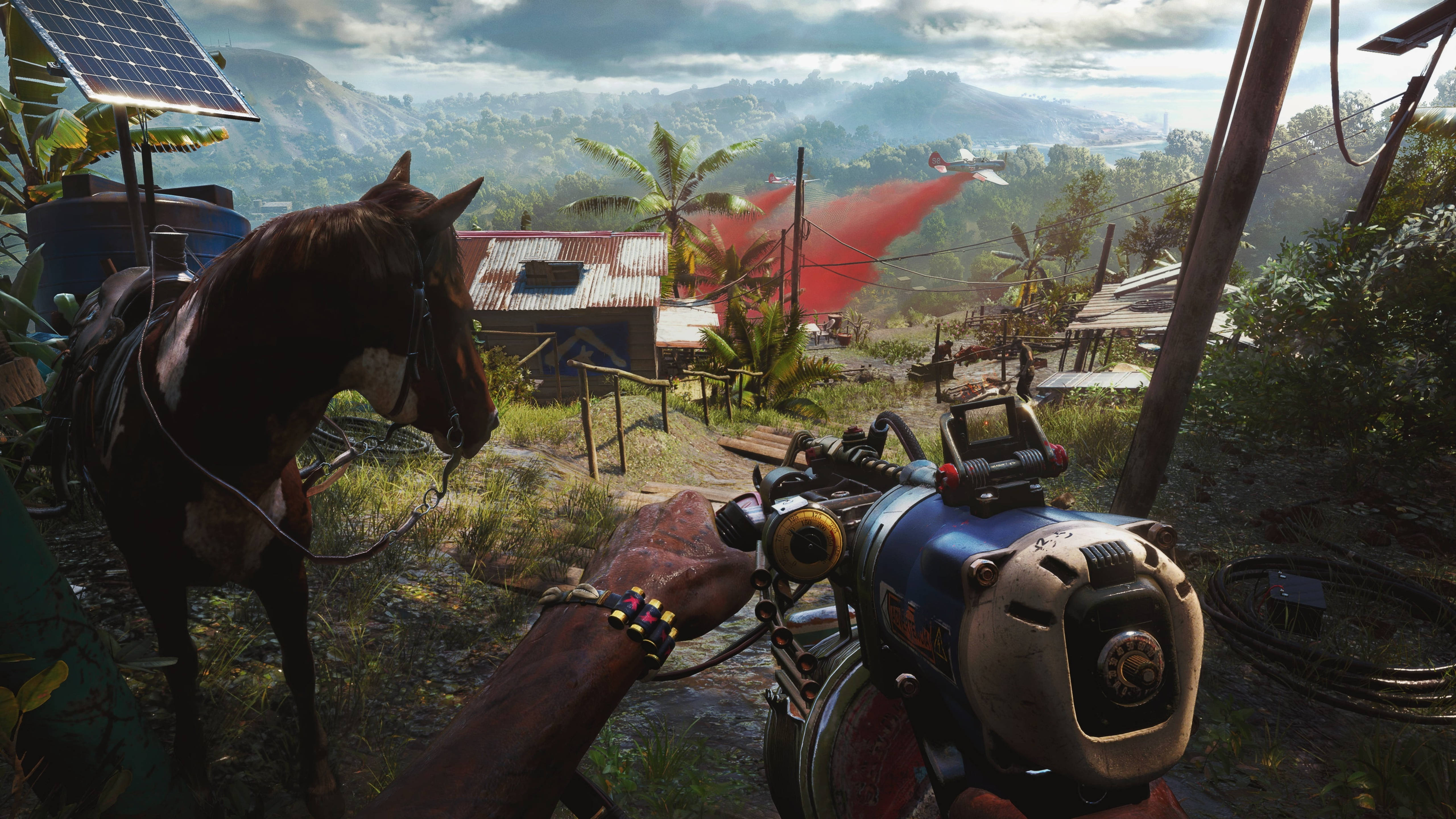 Far Cry 6 桌布 壁紙 — 玩家以第一人稱視角，在茂密的熱帶村莊中，手持科幻武器站在一匹備好鞍的馬旁邊，遠處有紅煙升起。