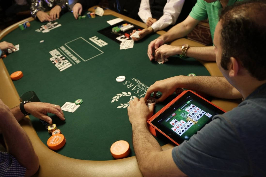 Playing Cards 桌布 壁紙 — 玩家聚集在一張綠色賭桌旁，在燈光昏暗的賭場房間裡下注和出牌。