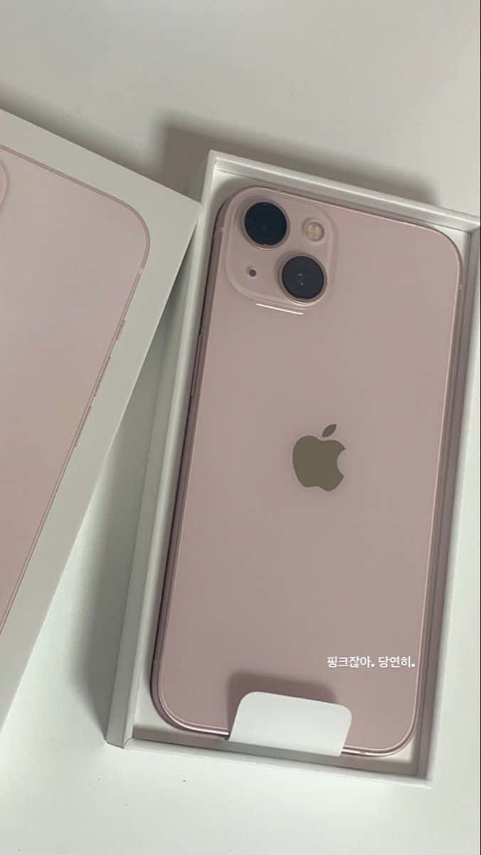 iPhone 12 桌布 壁紙 — 玫瑰金色 iPhone 13 mini 放在打開的白色盒子中，旁邊隱約可見另一部手機。
