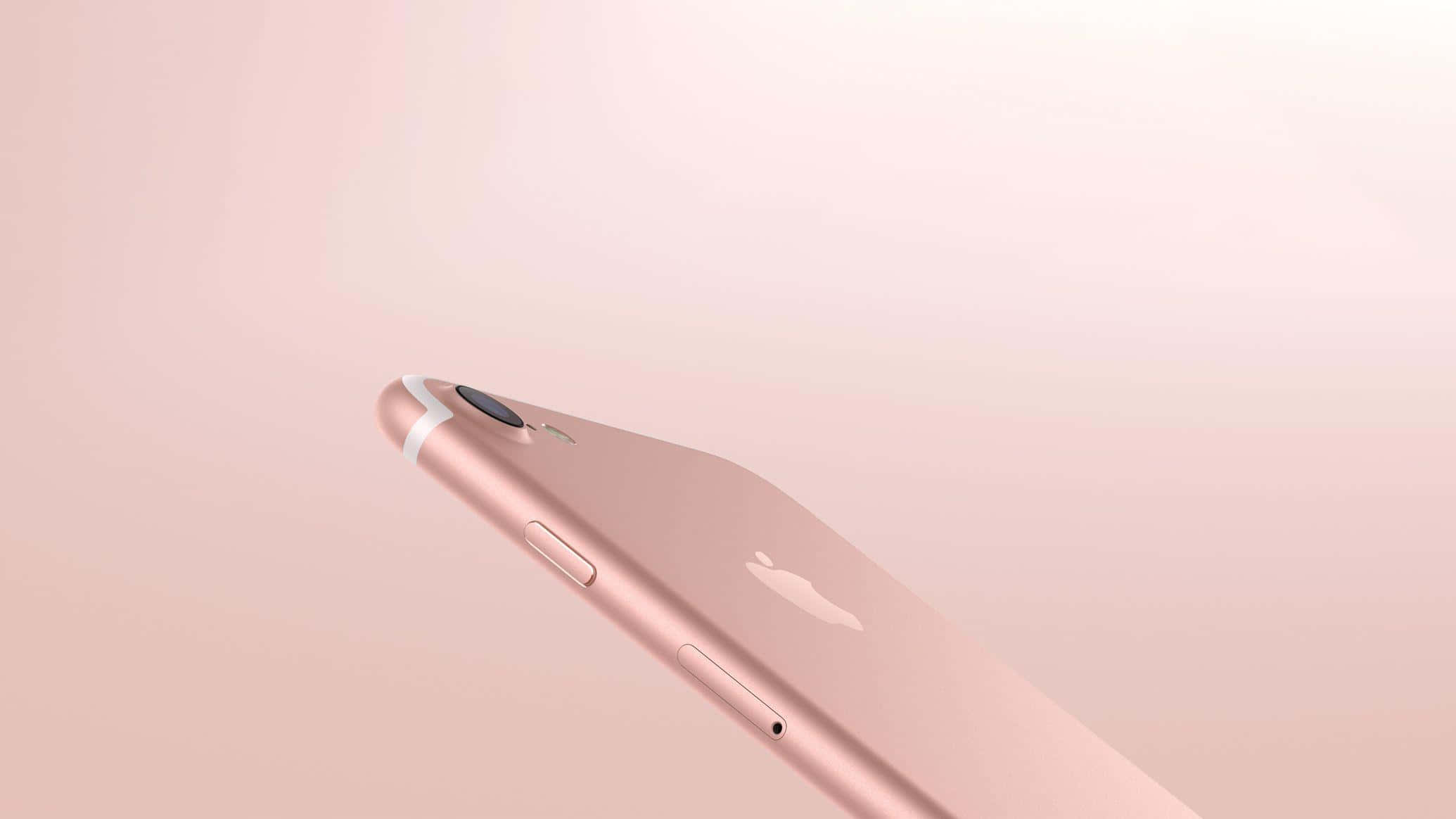 Rose Gold Color 桌布 壁紙 — 玫瑰金色iPhone傾斜放置於柔和漸變粉紅色背景上，搭配極簡燈光。