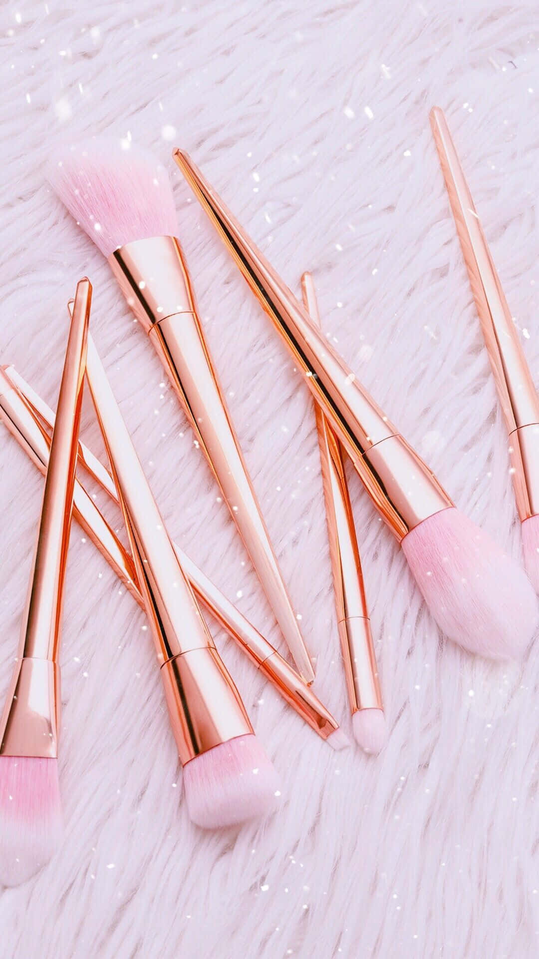 Cosmetic 桌布 壁紙 — 玫瑰金色化妝刷搭配柔軟粉紅色刷毛，放置在灑滿亮粉的蓬鬆白色表面上。