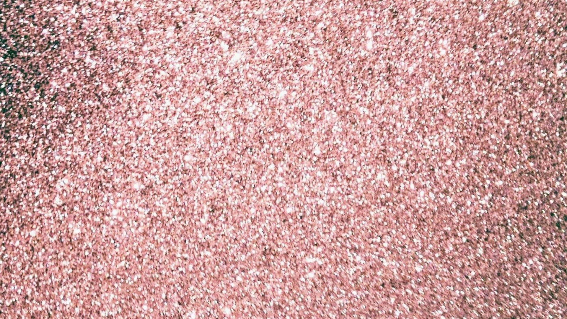 Aesthetic Rose Gold 桌布 壁紙 — 玫瑰金閃粉的特寫，散落著白色斑點，營造出閃爍的紋理表面。