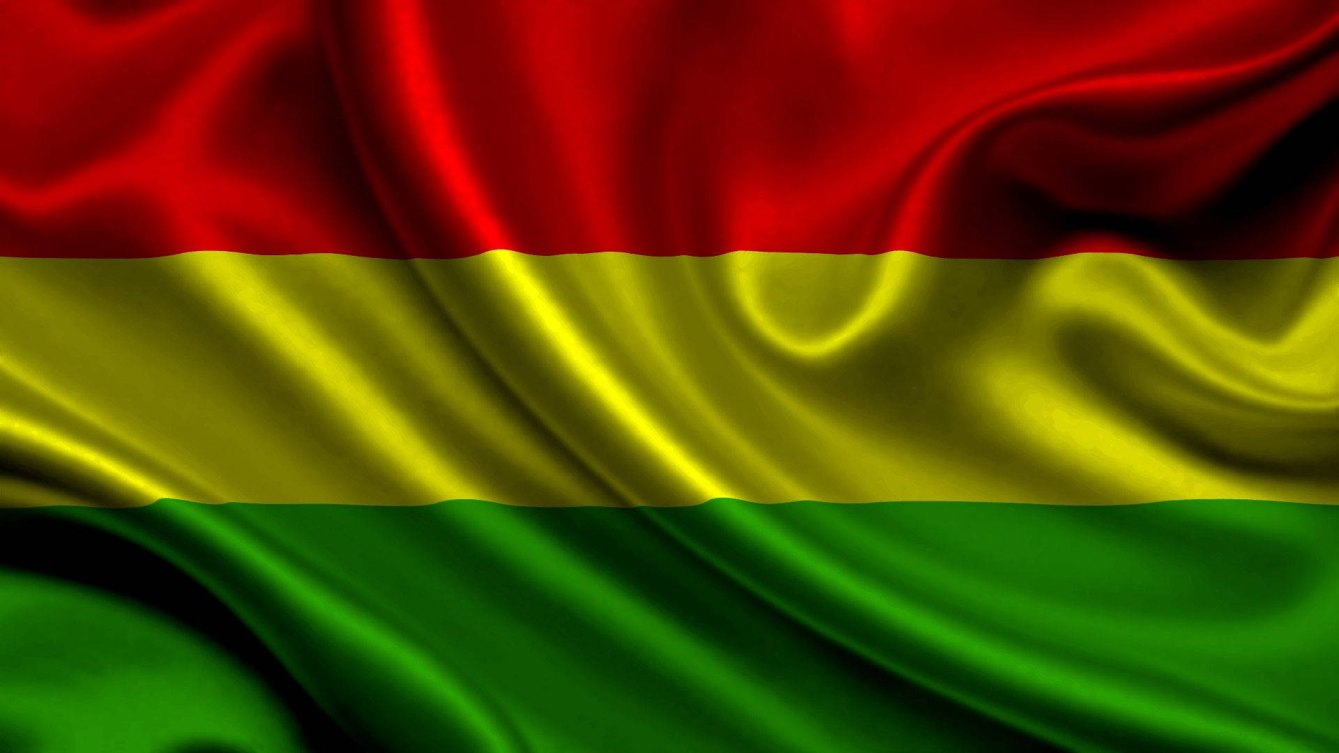 Bolivia 桌布 壁紙 — 玻利維亞國旗的特寫，豐富的紅、黃、綠色橫條紋在柔軟的布料褶皺中飄動。