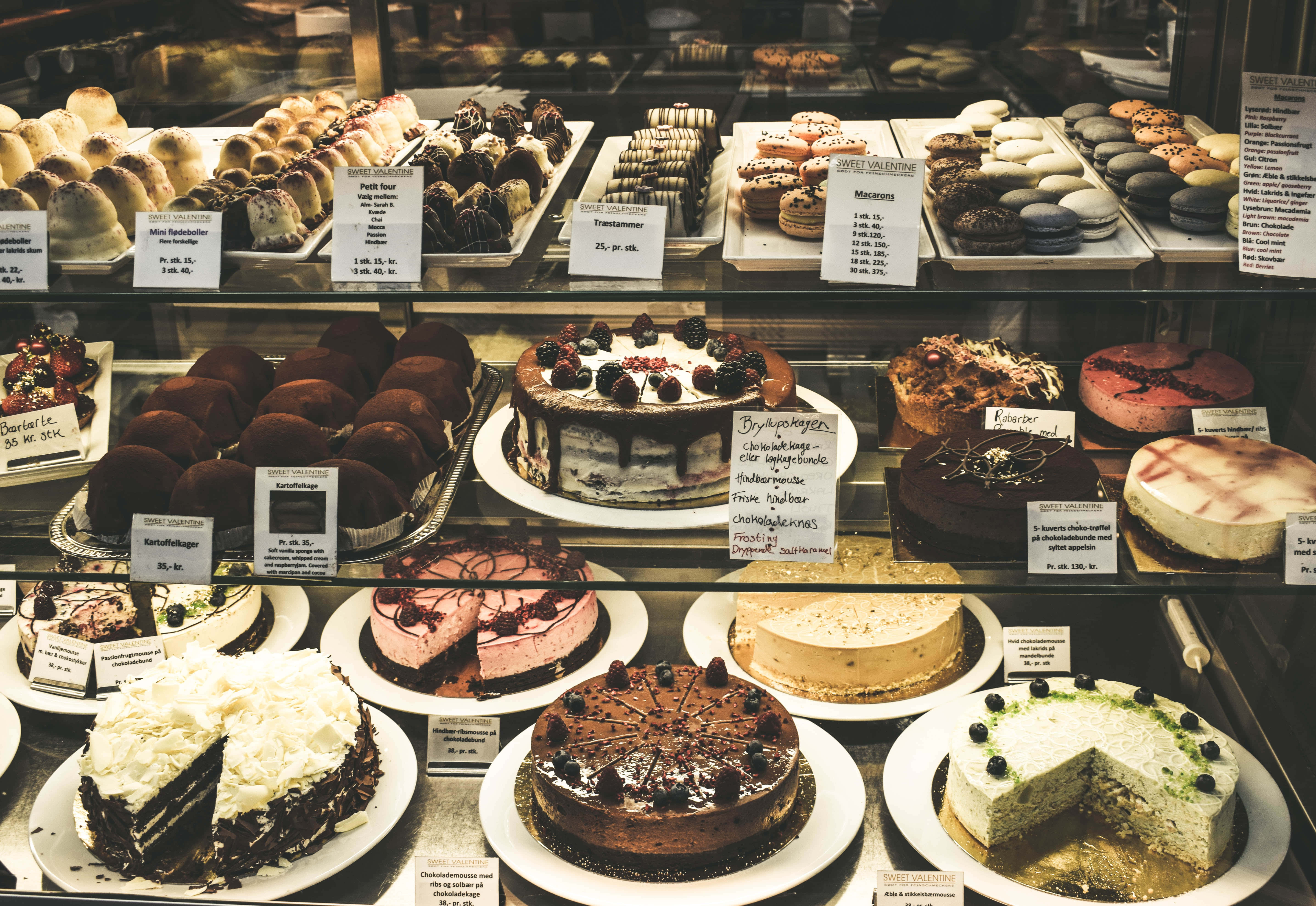 Bakery 桌布 壁紙 — 玻璃展示櫃裡擺滿了頹廢的蛋糕、糕點和馬卡龍，誘人地排列出售。