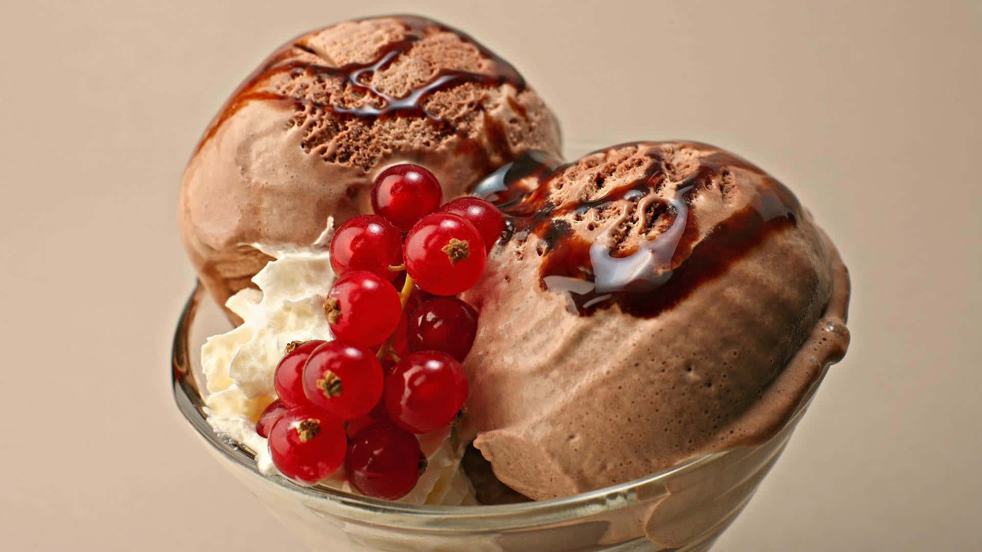Ice Cream 桌布 壁紙 — 玻璃碗中兩球濃郁巧克力冰淇淋，配上亮面醬汁、鮮奶油和一簇鮮紅的紅醋栗。