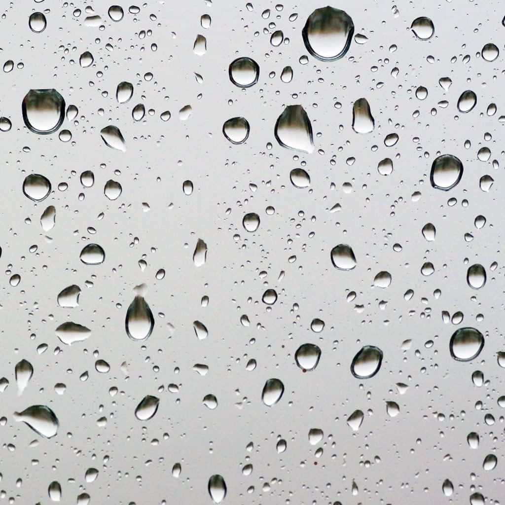 桌布 壁紙 — 玻璃表面上的雨滴特寫，映照出暗淡的灰色天空。