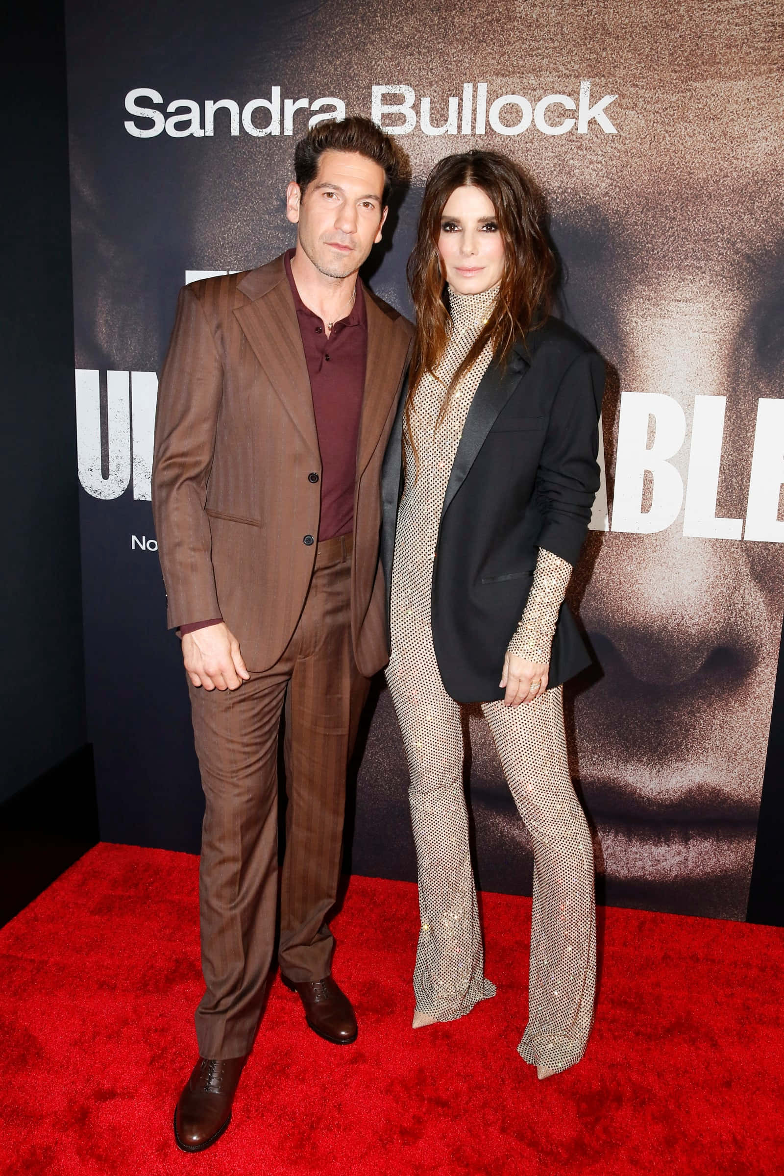 Sandra Bullock 2021 桌布 壁紙 — 珊卓·布拉克與一名男子在電影海報背景前的紅地毯上合影。
