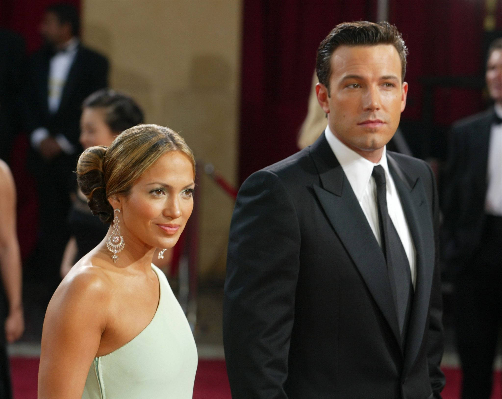 Ben Affleck 桌布 壁紙 — 珍妮佛·羅培茲和班·艾佛列克在明亮的活動燈光下，穿著正式晚裝自信地在紅地毯上擺姿勢。