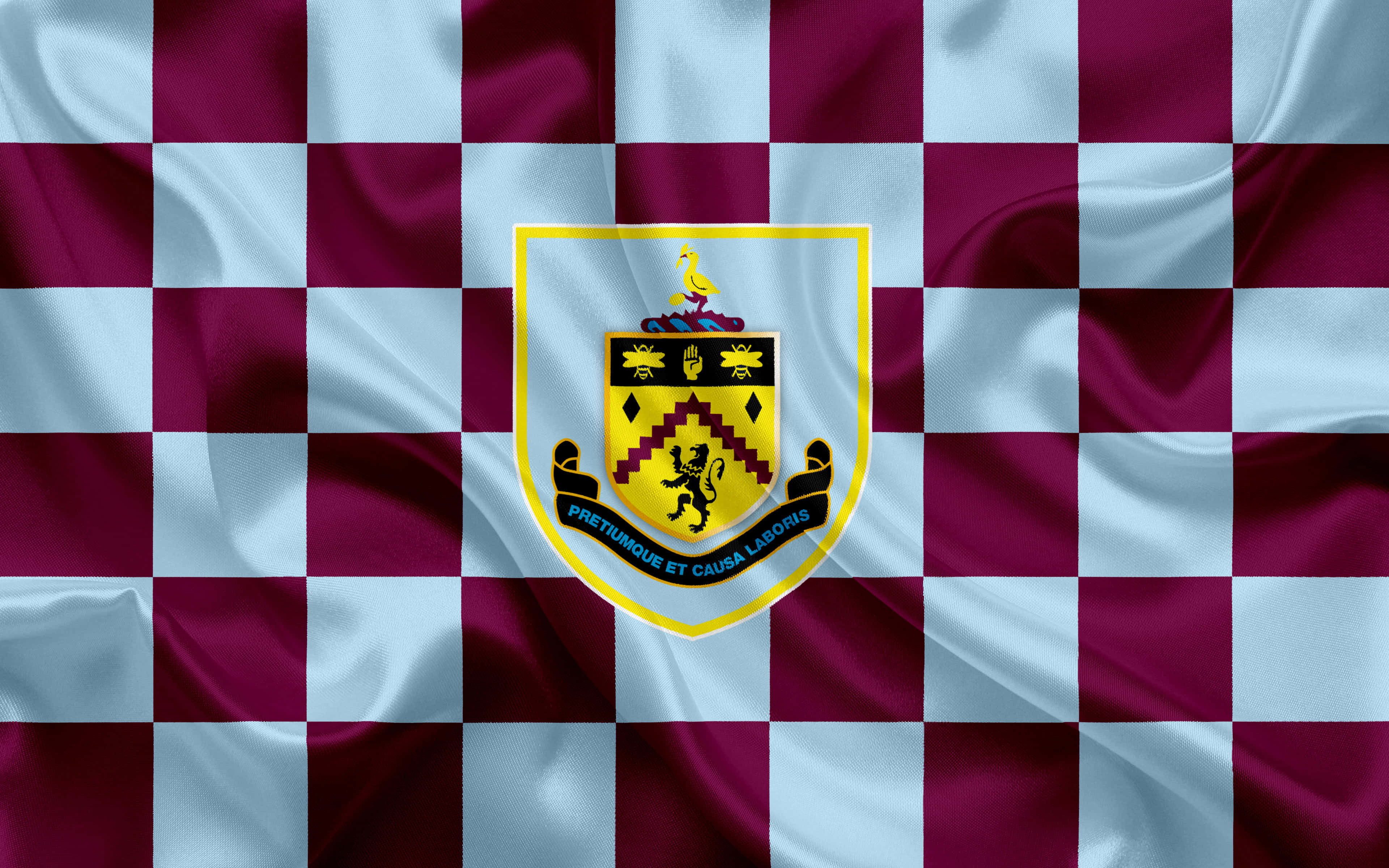Burnley Fc 桌布 壁紙 — 班斯利足球俱樂部旗幟的特寫，帶有栗色和淺藍色格紋布料及中央徽章。