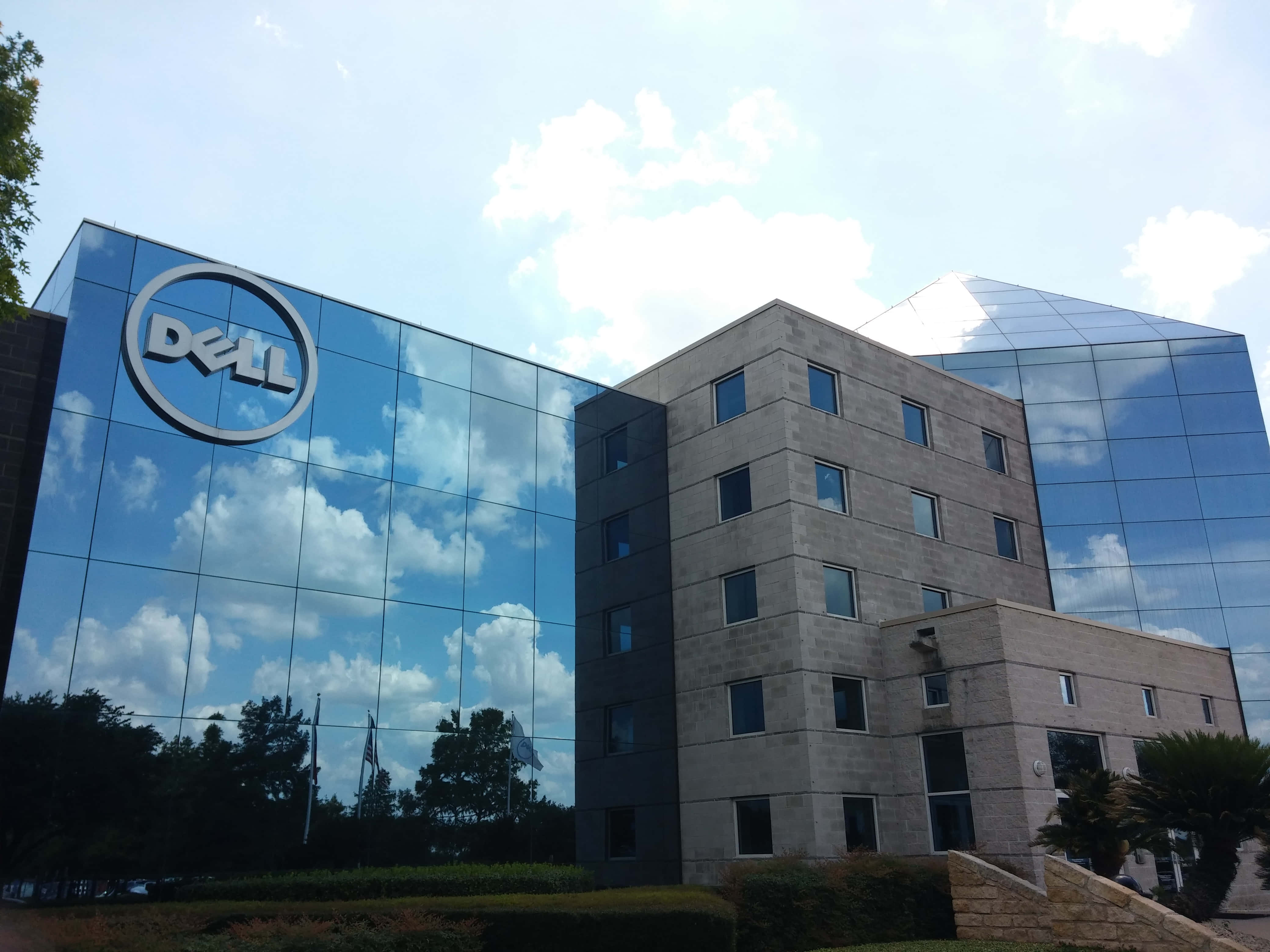Dell 桌布 壁紙 — 現代Dell企業大樓，玻璃幕牆在明亮日光下反射藍天白雲。