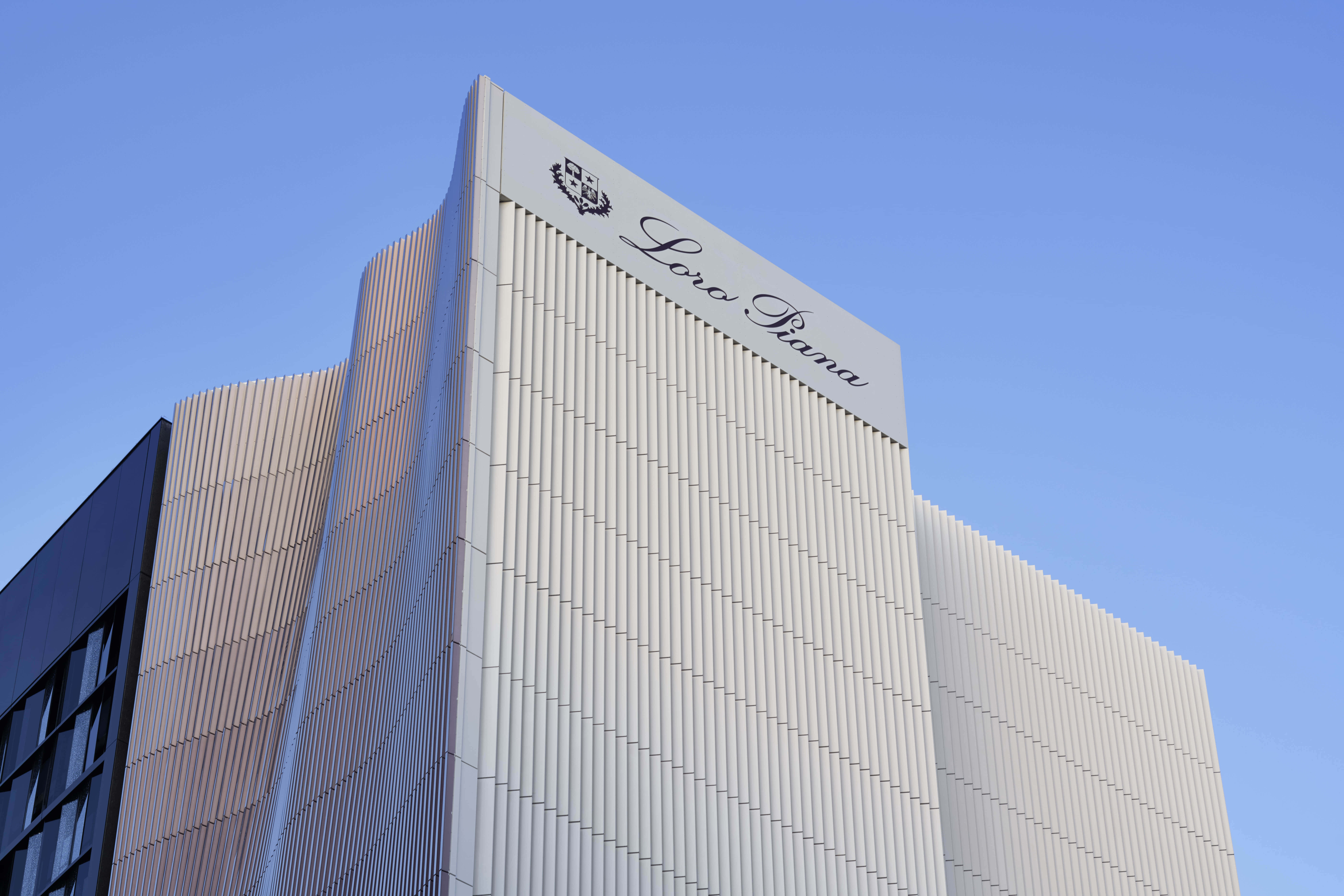 Building 桌布 壁紙 — 現代Loro Piana建築，採用時尚垂直壁板，背景為清澈藍天。