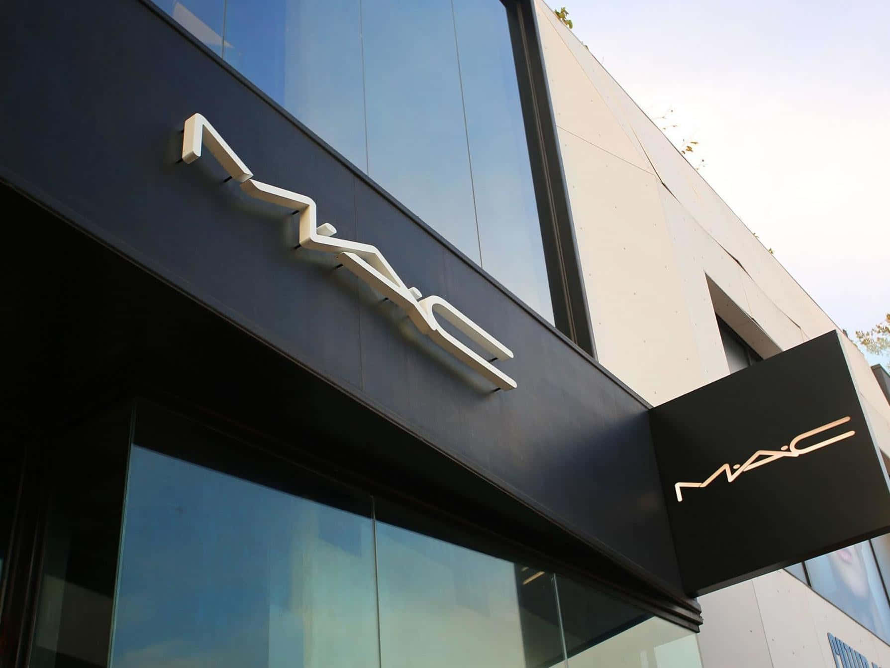 Mac Cosmetics 桌布 壁紙 — 現代MAC化妝品店鋪外觀，採用時尚黑色招牌和反光玻璃窗，在明亮日光下。