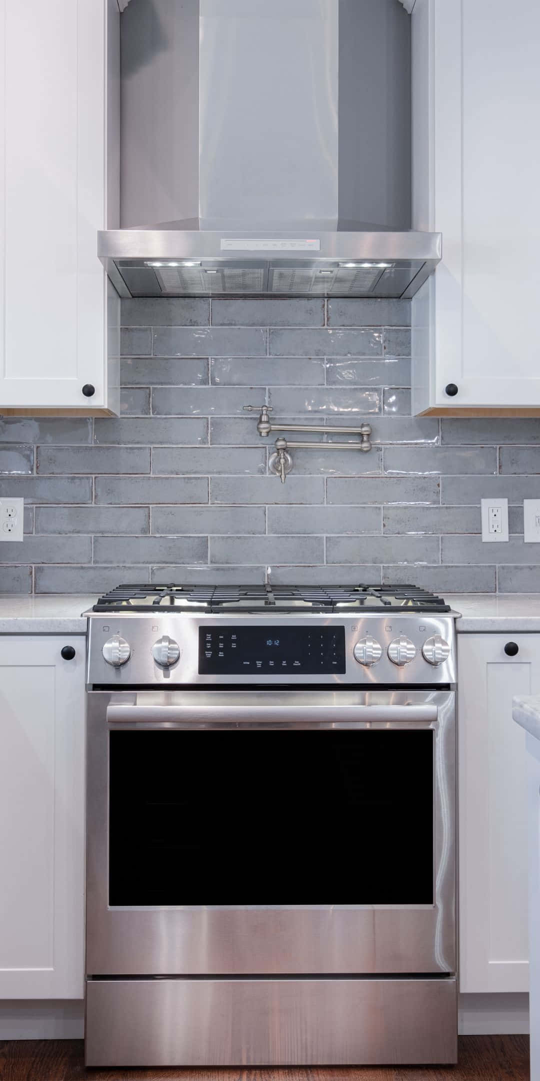 Pixel 3 Kitchen 桌布 壁紙 — 現代不鏽鋼爐具，配備數位控制，以灰色地鐵磚防濺板和白色櫥櫃為背景。