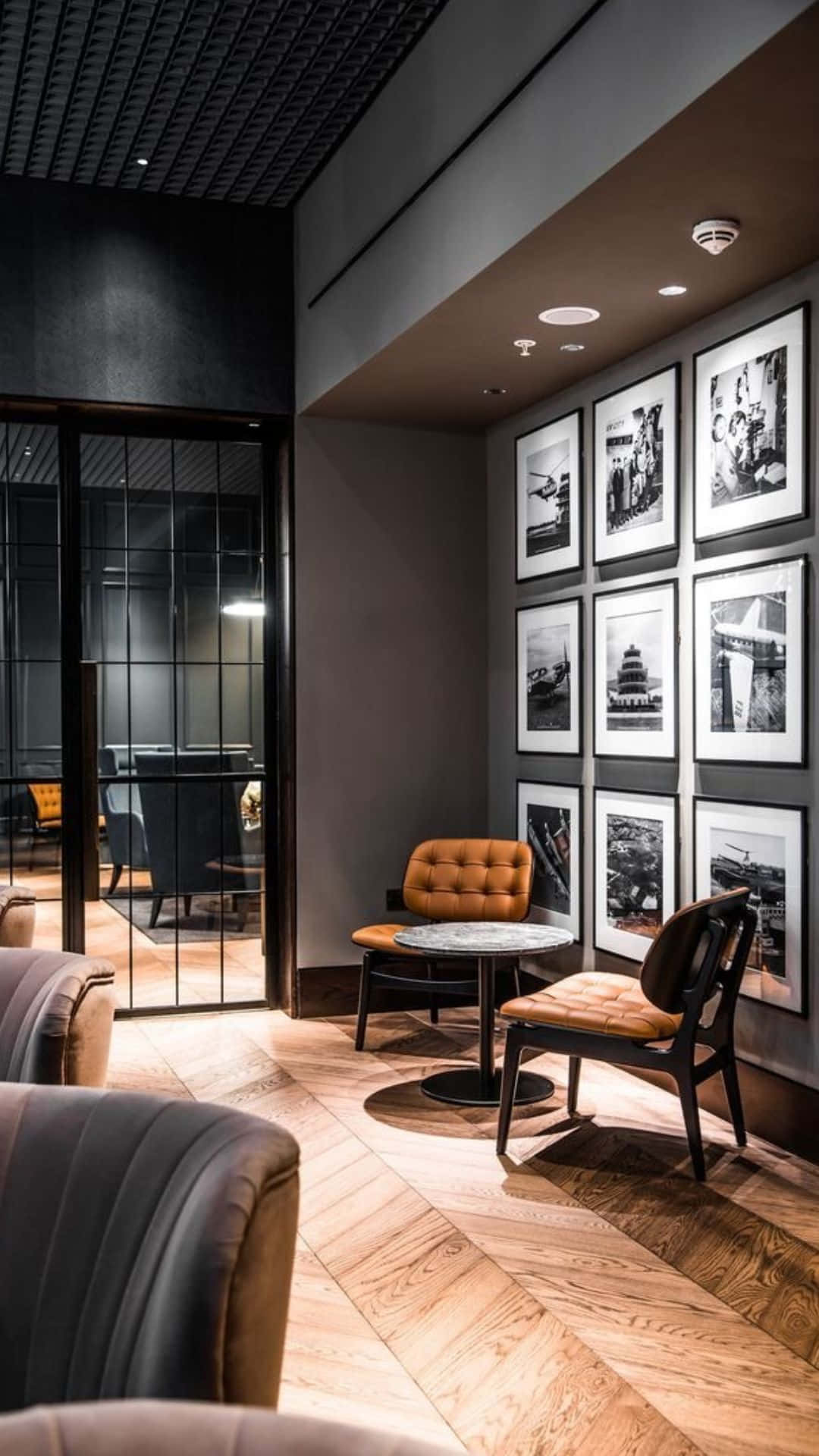 Modern Office 桌布 壁紙 — 現代休息室，配有溫暖木地板和橙色簇絨椅，柔和天花板燈光下。