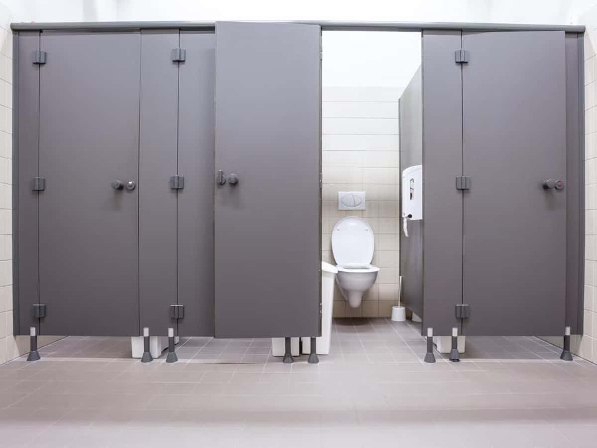 Toilet 桌布 壁紙 — 現代公共洗手間，設有灰色隔間及白色磁磚牆壁和地板。