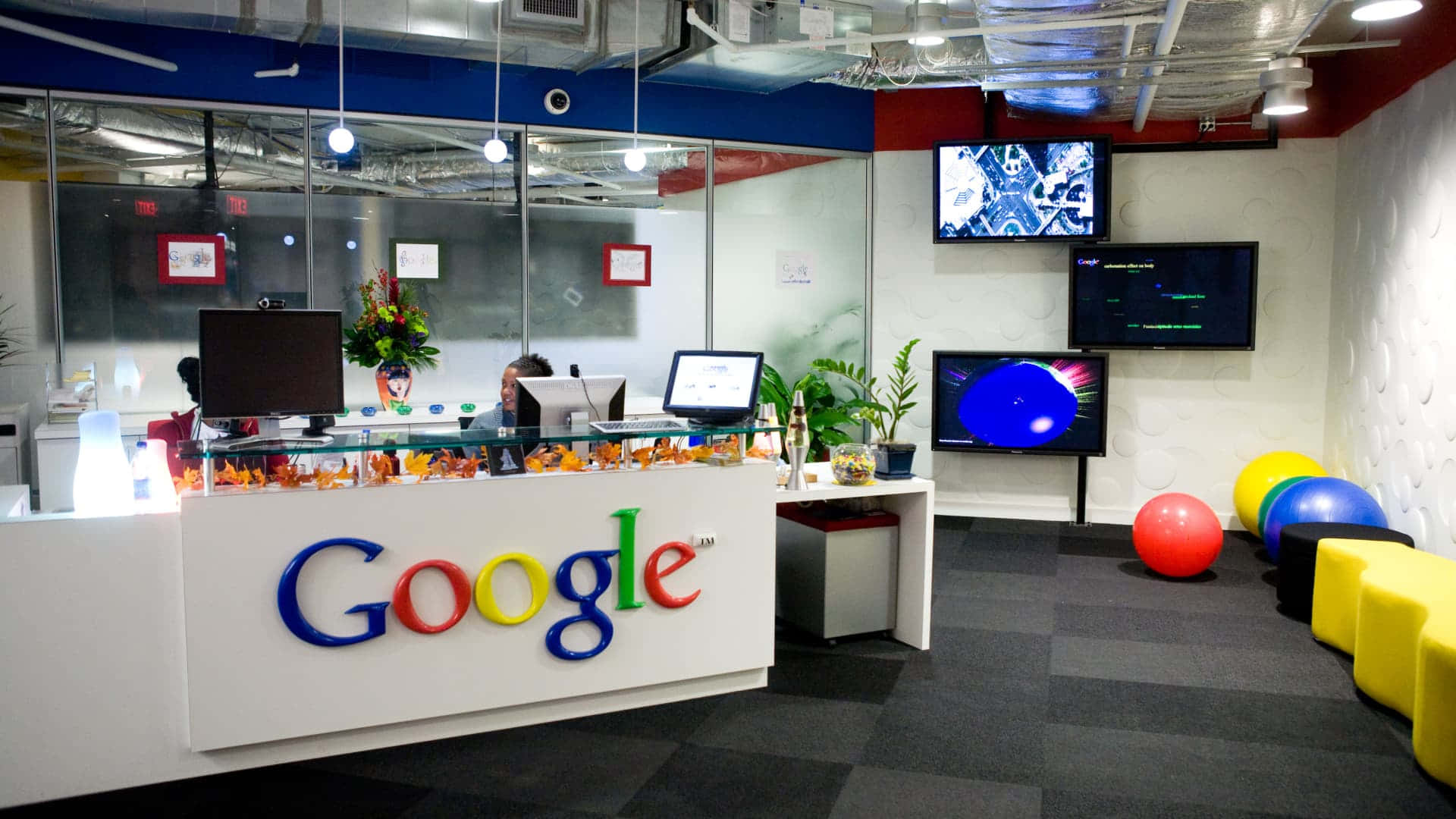Google 辦公室接待處，配有彩色標誌和趣味裝飾。 — Google Meet 壁紙