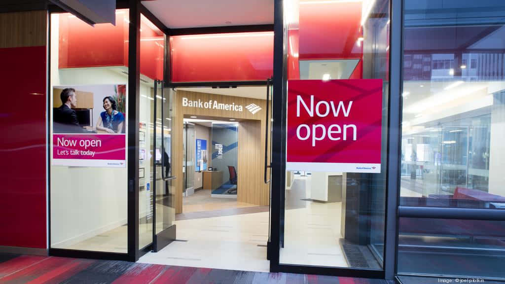 Bank Of America 桌布 壁紙 — 現代化的美國銀行分行入口，設有玻璃門和醒目的紅色標牌，在時尚的室內燈光下宣佈「現已開業」。