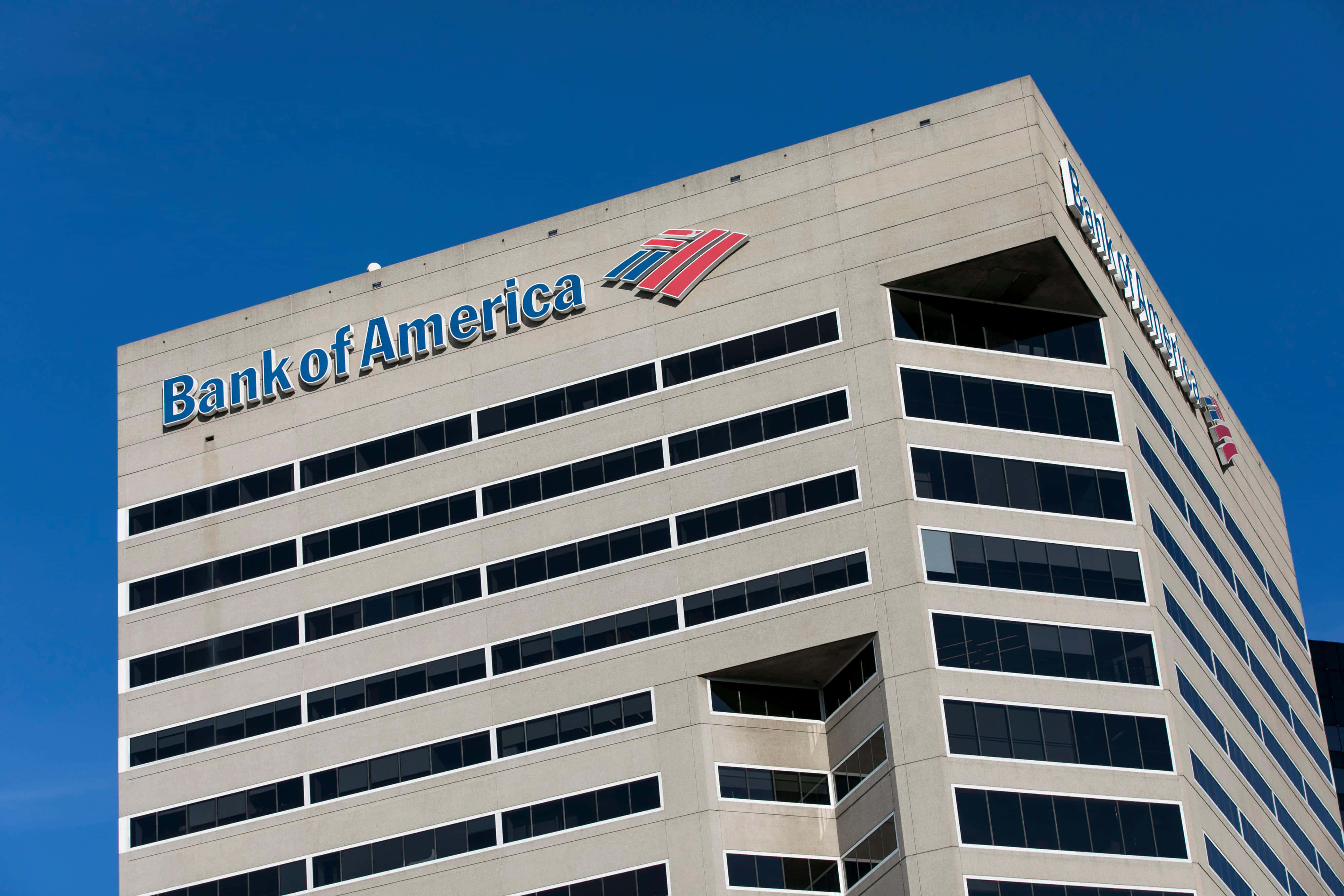 Bank Of America 桌布 壁紙 — 現代化的美國銀行摩天大樓，配備玻璃窗和醒目招牌，背景是清澈的藍天。