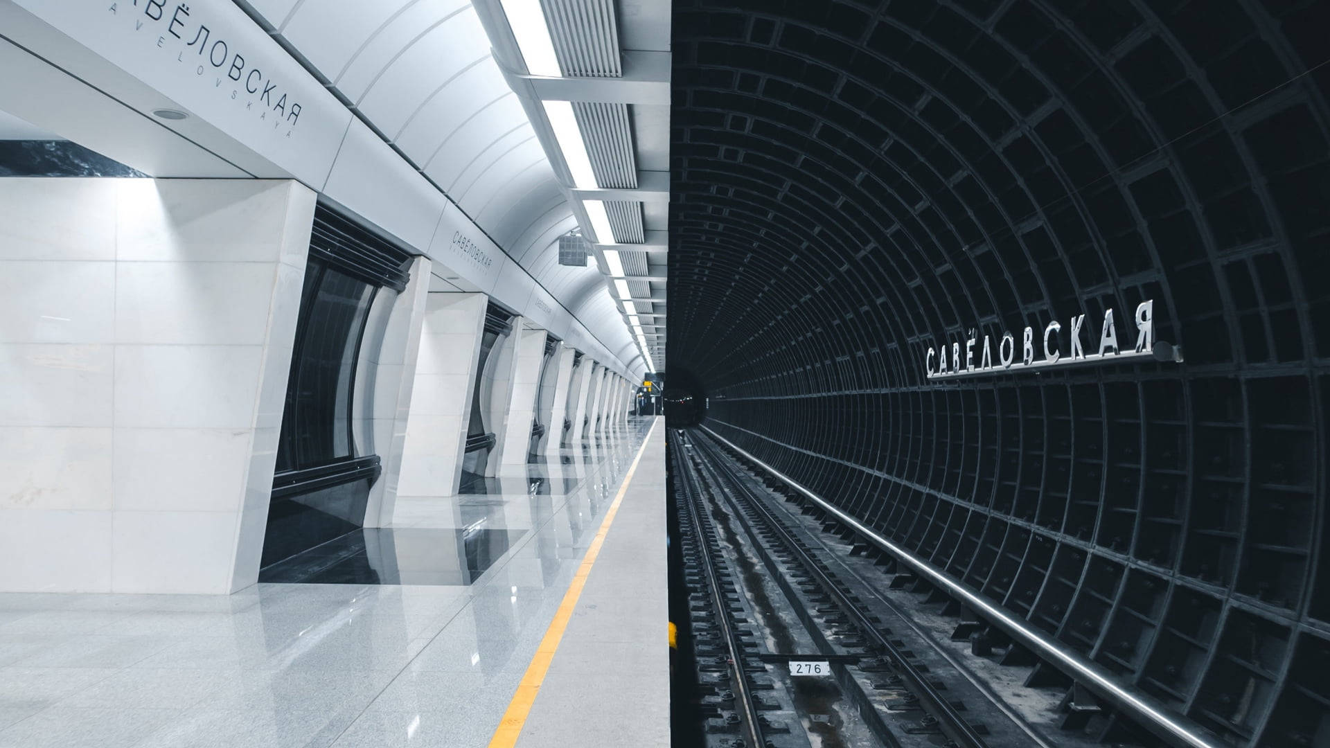 Subway 桌布 壁紙 — 現代地鐵站月台與黑暗隧道帶有西里爾字母標誌的鮮明分割視圖。
