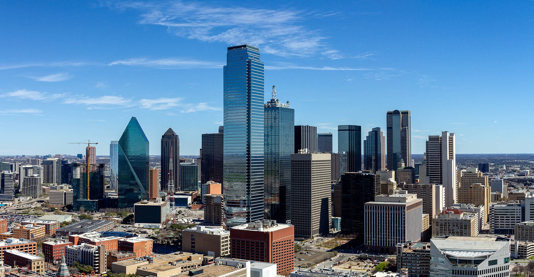 Dallas Skyline 桌布 壁紙 — 現代城市天際線的鳥瞰圖，玻璃摩天大樓在清澈藍天和薄雲下。