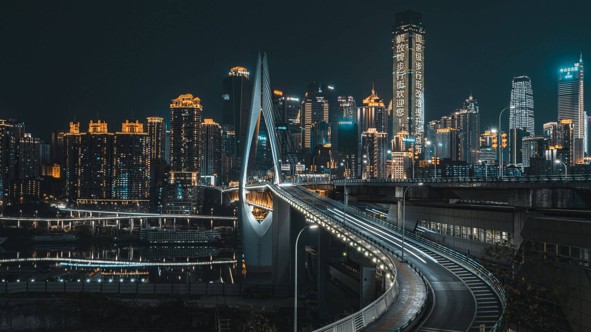 Chongqing 桌布 壁紙 — 現代城市景觀的壯麗夜景，發光的橋樑和燈火通明的摩天大樓倒映在水面上。