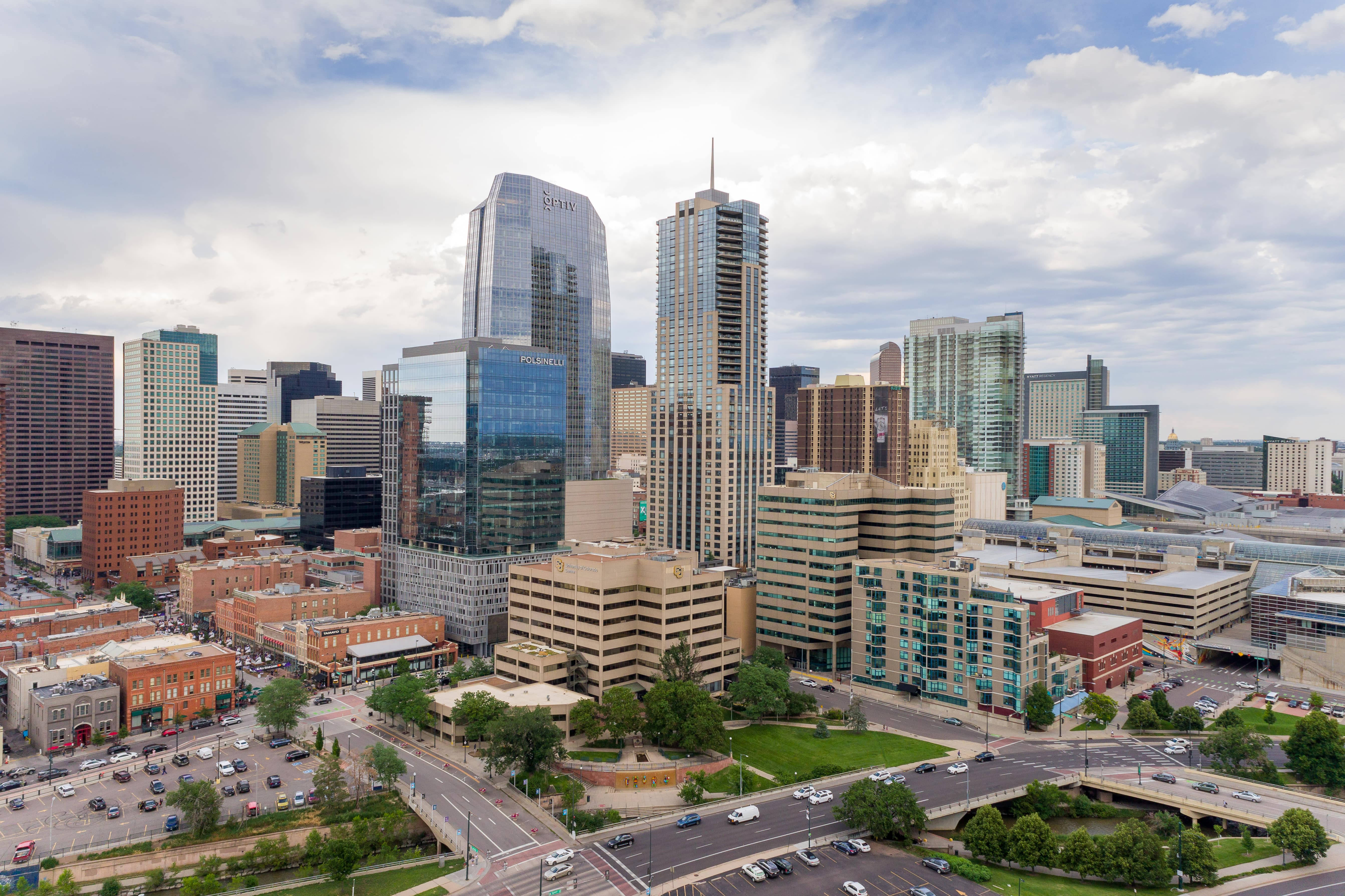 Colorado 桌布 壁紙 — 現代城市景觀的鳥瞰圖，包括玻璃摩天大樓、磚砌建築和繁忙的道路，天空部分多雲。